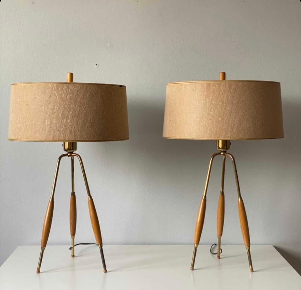 Amazing set of original Gerald Thurston tripod lamps (larger & rarer version) with milk glass reflectors. Made by Lightolier. Original shades and finials. Original wiring. Lovely walnut spindles with long brass legs. Normal wear. Slight splits in