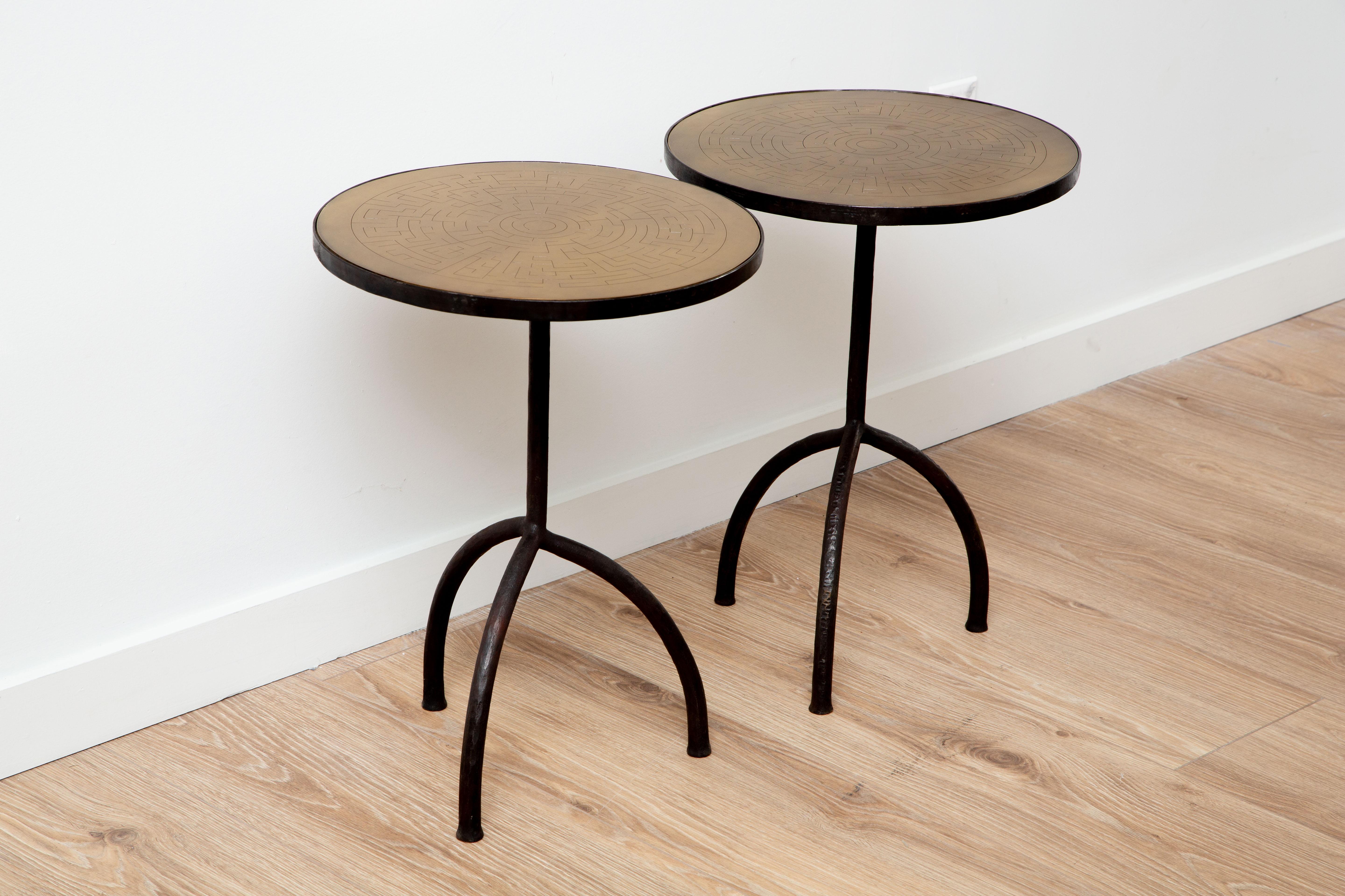 Pair of tripod wrought iron with etched brass top side tables, in stock.
This stunning wrought iron tripod side table is an eye-catching addition to any home decor. Its brass round top with etched Greek key accent, and its hammered metal frame has