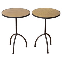 Coppia di tavolini tripodi in ferro battuto con piano in ottone acidato, in stock