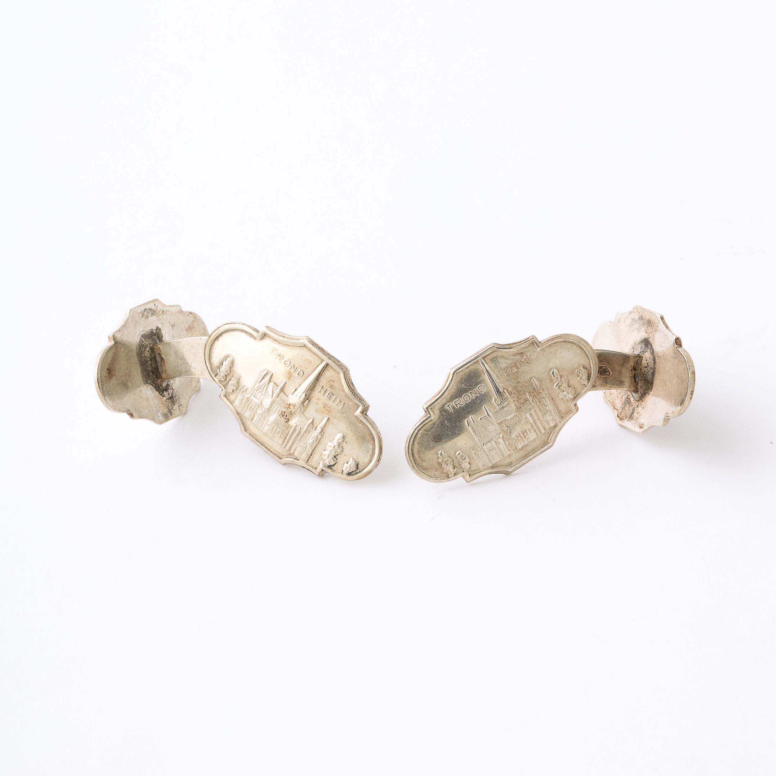 Cette ravissante paire de boutons de manchette en argent sterling provient de Trond Heim Norvège et date de la fin du XIXe siècle. Elle représente un paysage de la cathédrale de Nidaros, avec plusieurs arbres peuplant l'horizon et donnant de