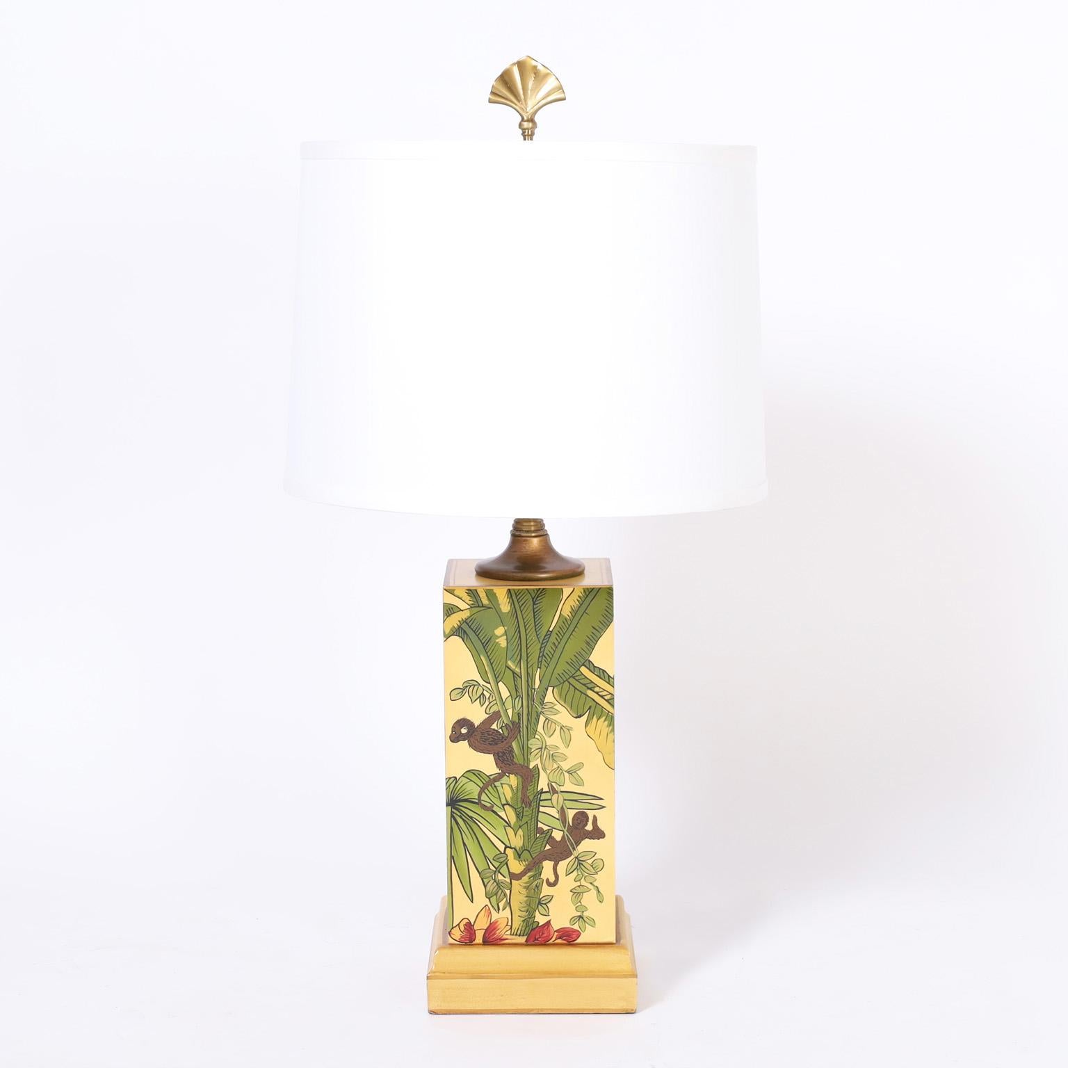 Pair of mid century table lamps crafted in wood and decorated on four sides with tropical scenes and monkeys.