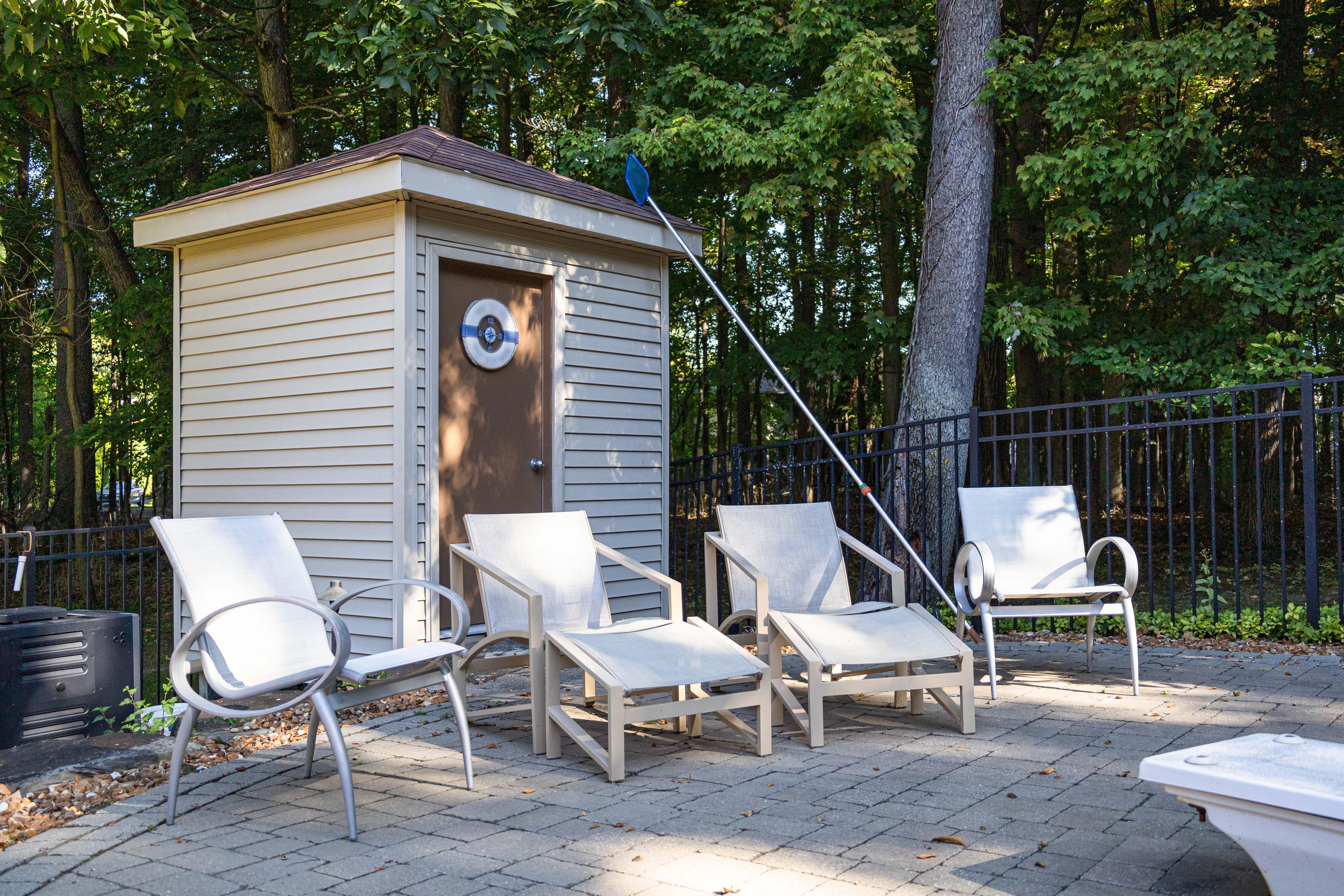 A pair of Tropitone outdoor patio armchairs. This is a beautiful set of modern patio chairs. Tropitone is known for their beautiful designs and lasting materials. These chairs feature a full aluminum frame and woven vinyl seats and backs. The frame