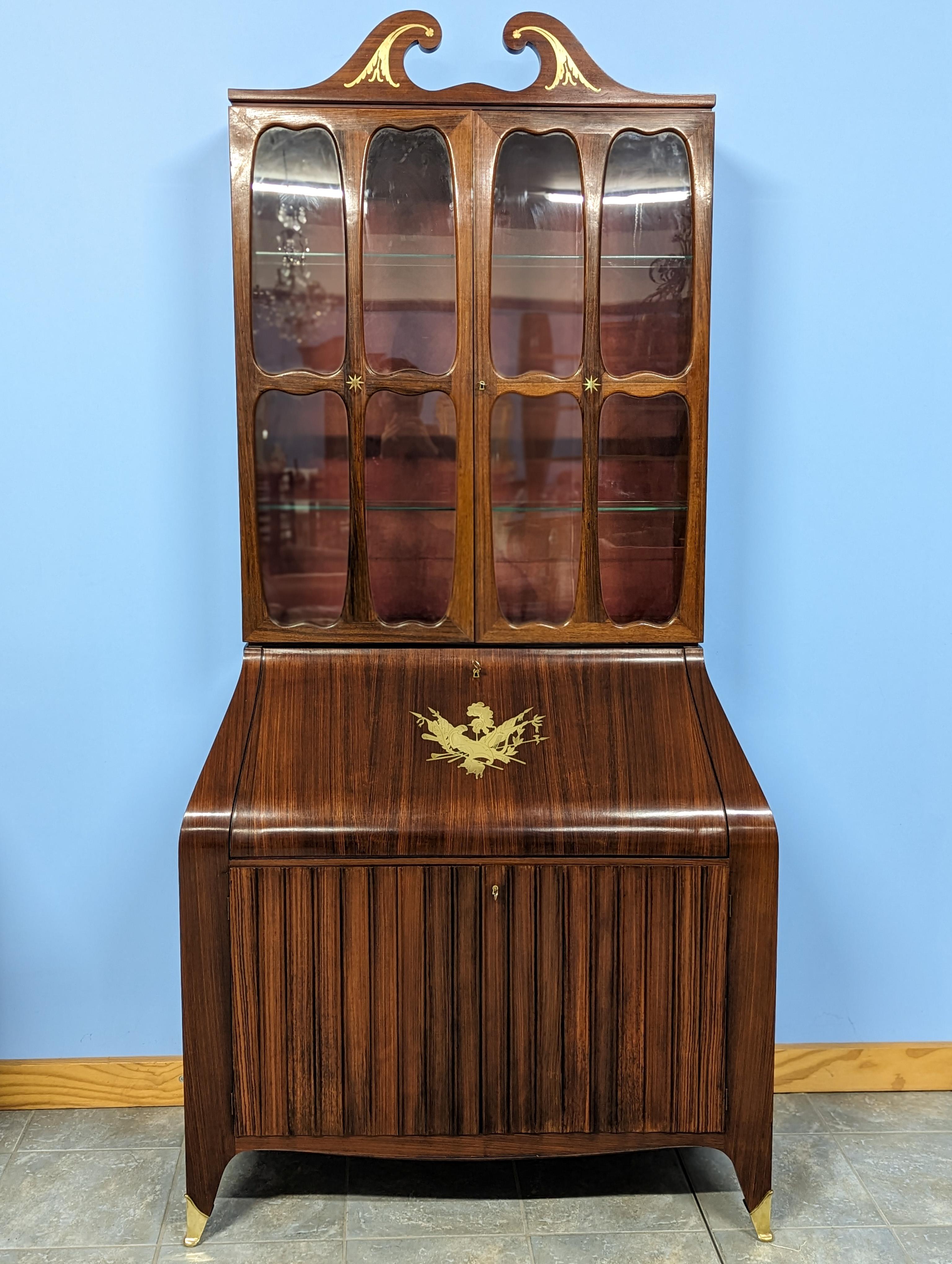 This exquisite Mahogany trumeau boasts a stunning design, featuring two doors at the base, along with an upper section that includes a showcase with two doors, a central connecting part with a flap door and an internal citronnier secretaire. The