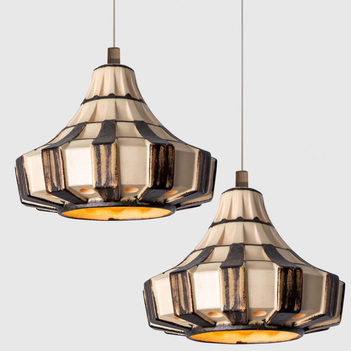 Pair of Stunning round hanging lamps with an unusual shape, made with rich brown and ivory striped ceramics, manufactured in the 1970s in Denmark. We also have a multitude of unique colored ceramic light sets and arrangements, all available on the