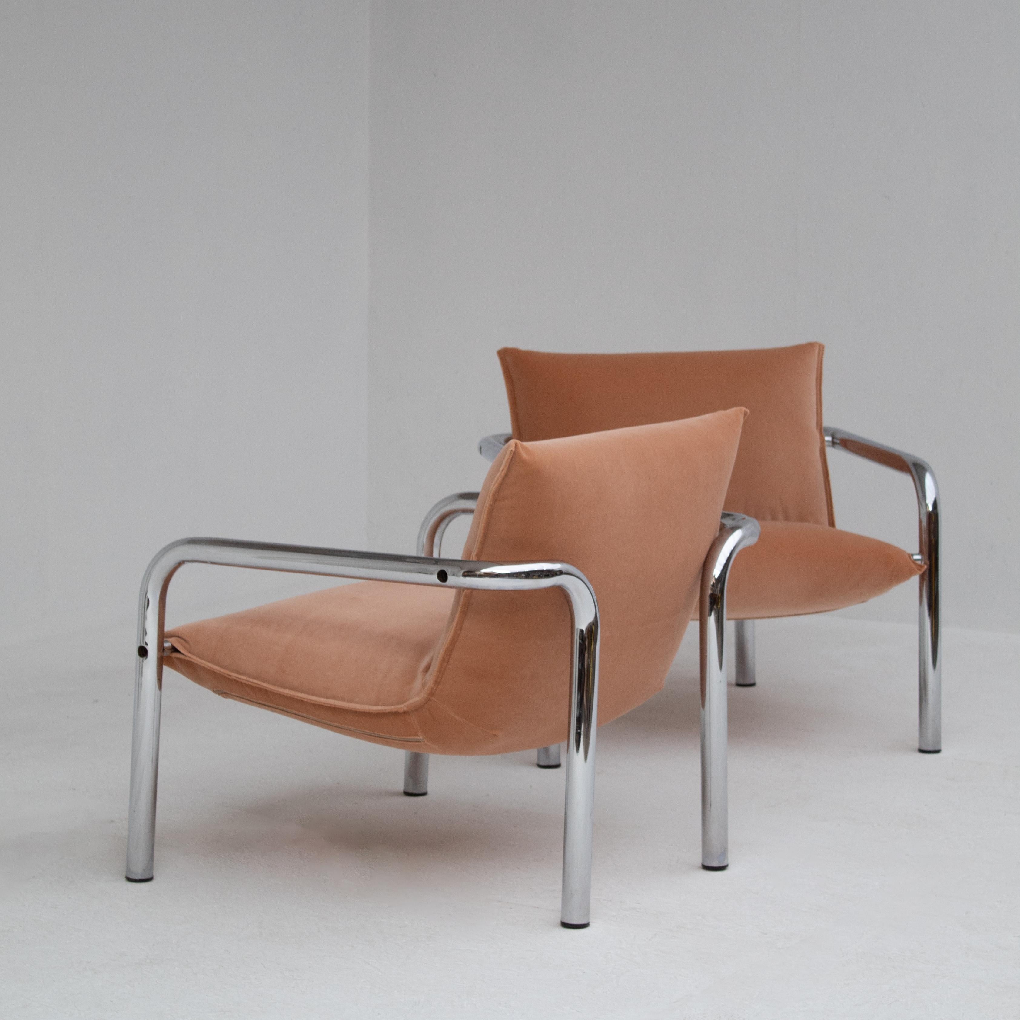 These tubular lounge chairs capture the optimism of the 1970s. Designers of that era loved chrome for its shine and modern look. The curved frames give the chairs a sculptural rhythm, while the salmon-colored velvet softens their bold lines. Sitting