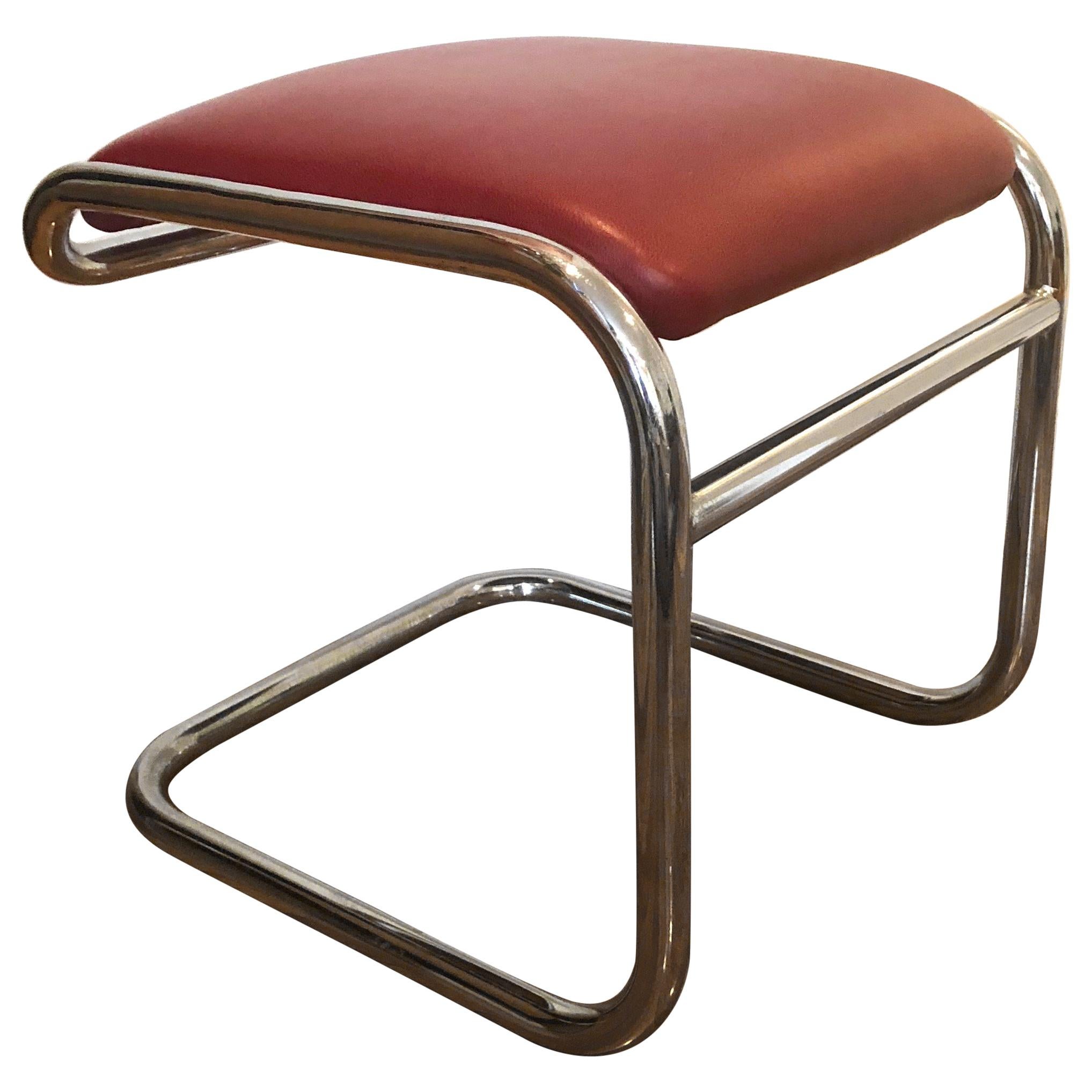 Pair of tubular chromed metal footstools with a horizontal stretcher and red leatherette upholstered seats.