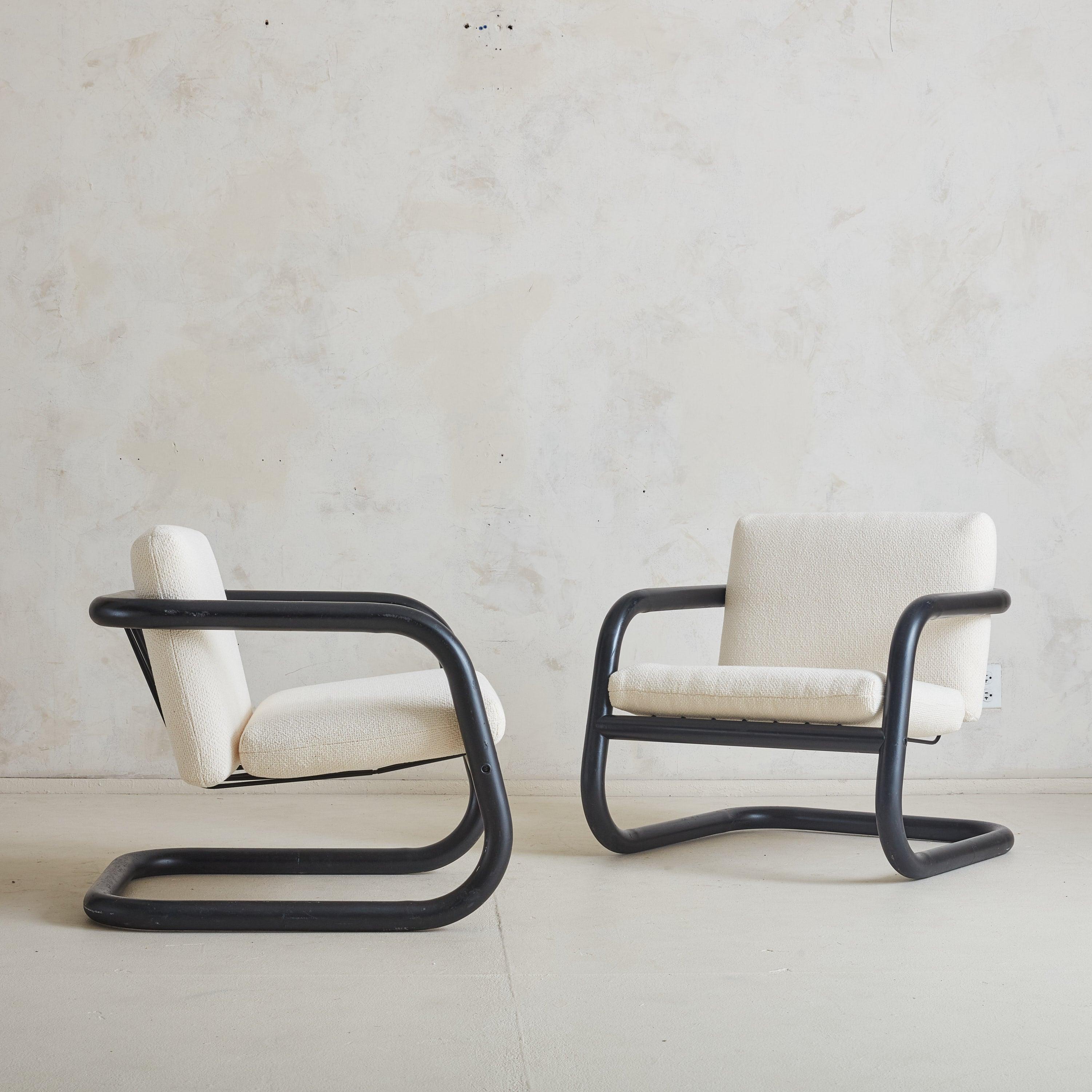Un par de sillones escultóricos realizados por el célebre arquitecto y diseñador brasileño Geraldo de Barros en la década de 1970. Cada armazón, construido con metal tubular negro, se dobla con curvas suaves y fluidas, cimentando el diseño en un