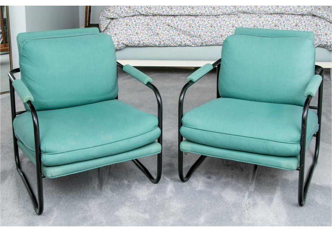 Pair of tubular armchairs from Pace Collection featuring matte black finished metal frame with upholstered seat, back and arms. Cushions are attached to seat back and seat. Colorful and comfortable. 

27