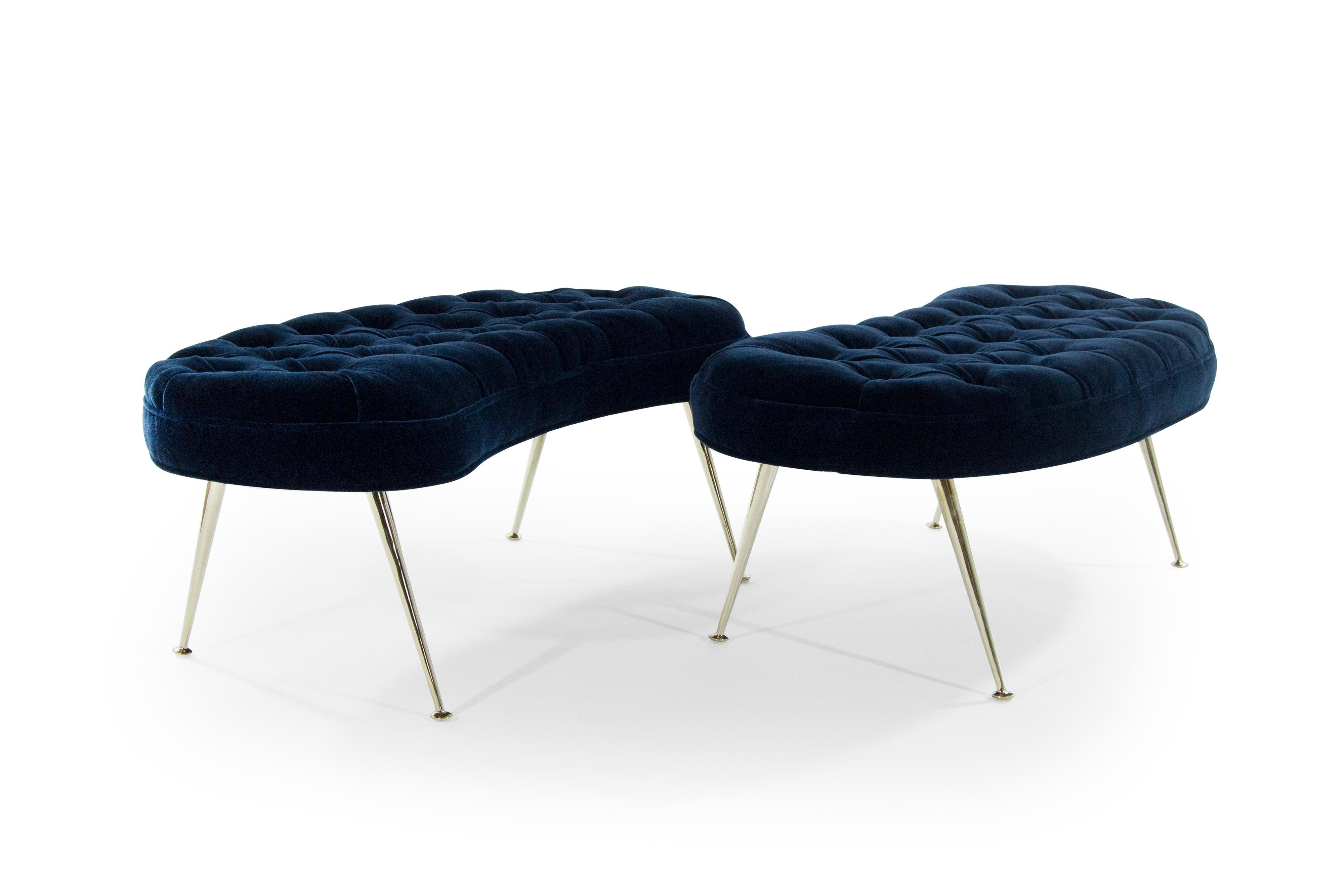 A fantastic pair of kidney shaped benches in tufted design, newly upholstered in midnight blue mohair by Donghia. Brass legs newly polished. Priced individually.