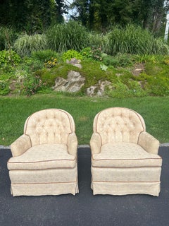 Pair of Tufted Button Back Swivel Chairs in a cream color with brown piping