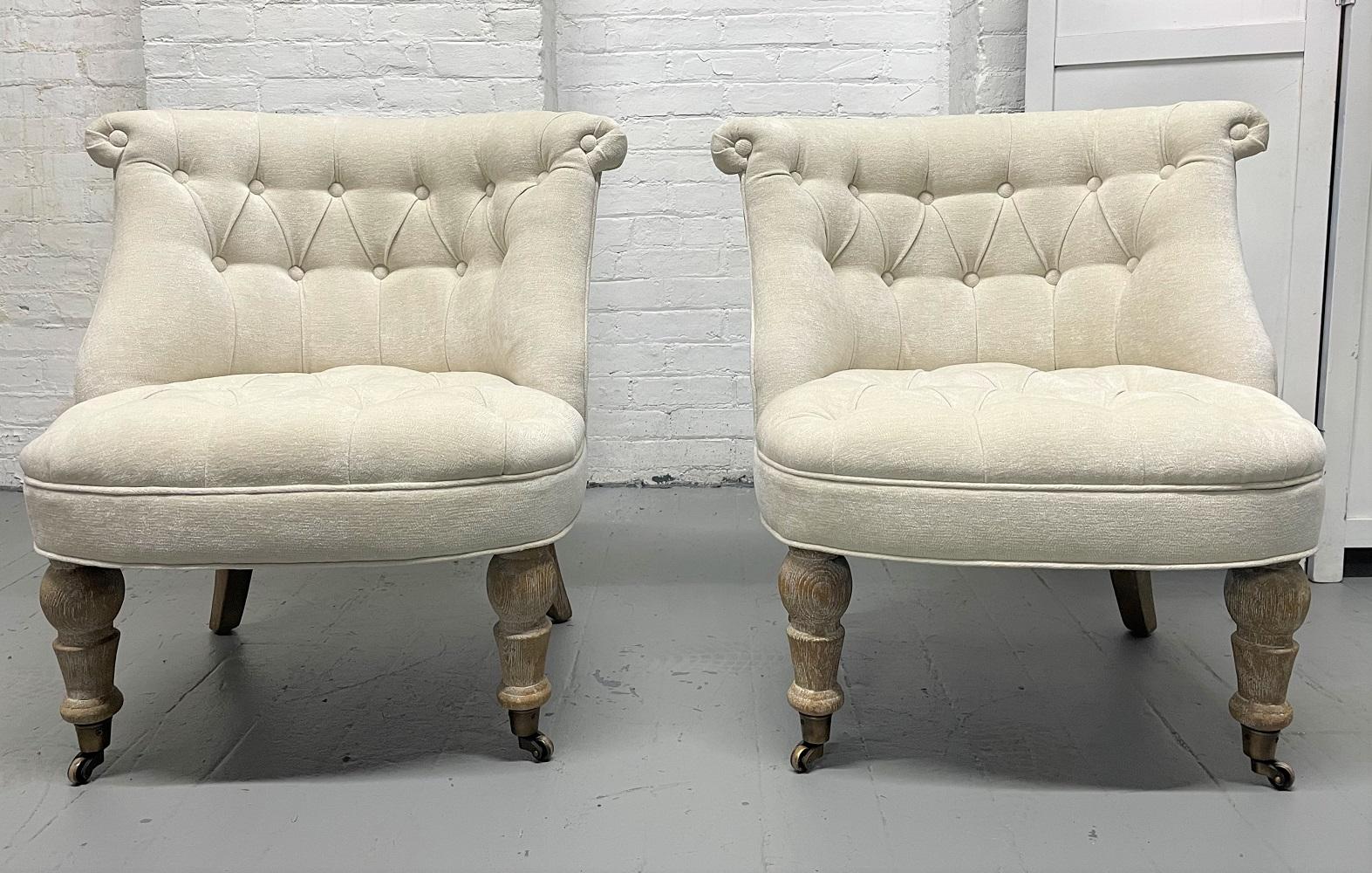 Pair of Tufted Cerused Lounge Slipper Chairs upholstered in a velvet fabric. The chairs have cerused oak legs with the front legs having casters.