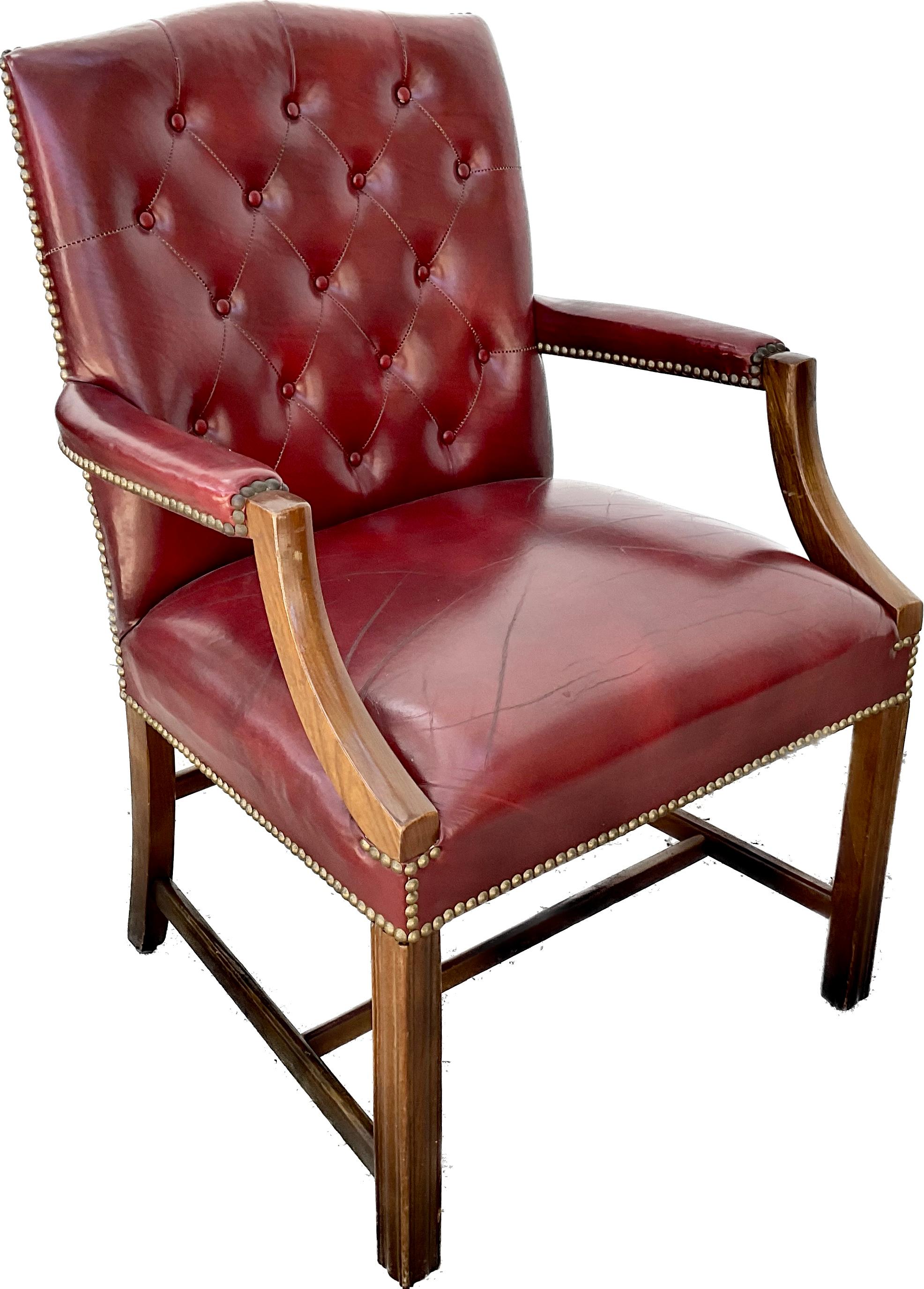 Pair of leather armchairs with wooden legs and stretcher. Done in the Chesterfield style. Beautiful Burgandy Leather appears to be original and slightly worn. Nail head detailing along all the edges.
The listing is for one pair of armchairs. We