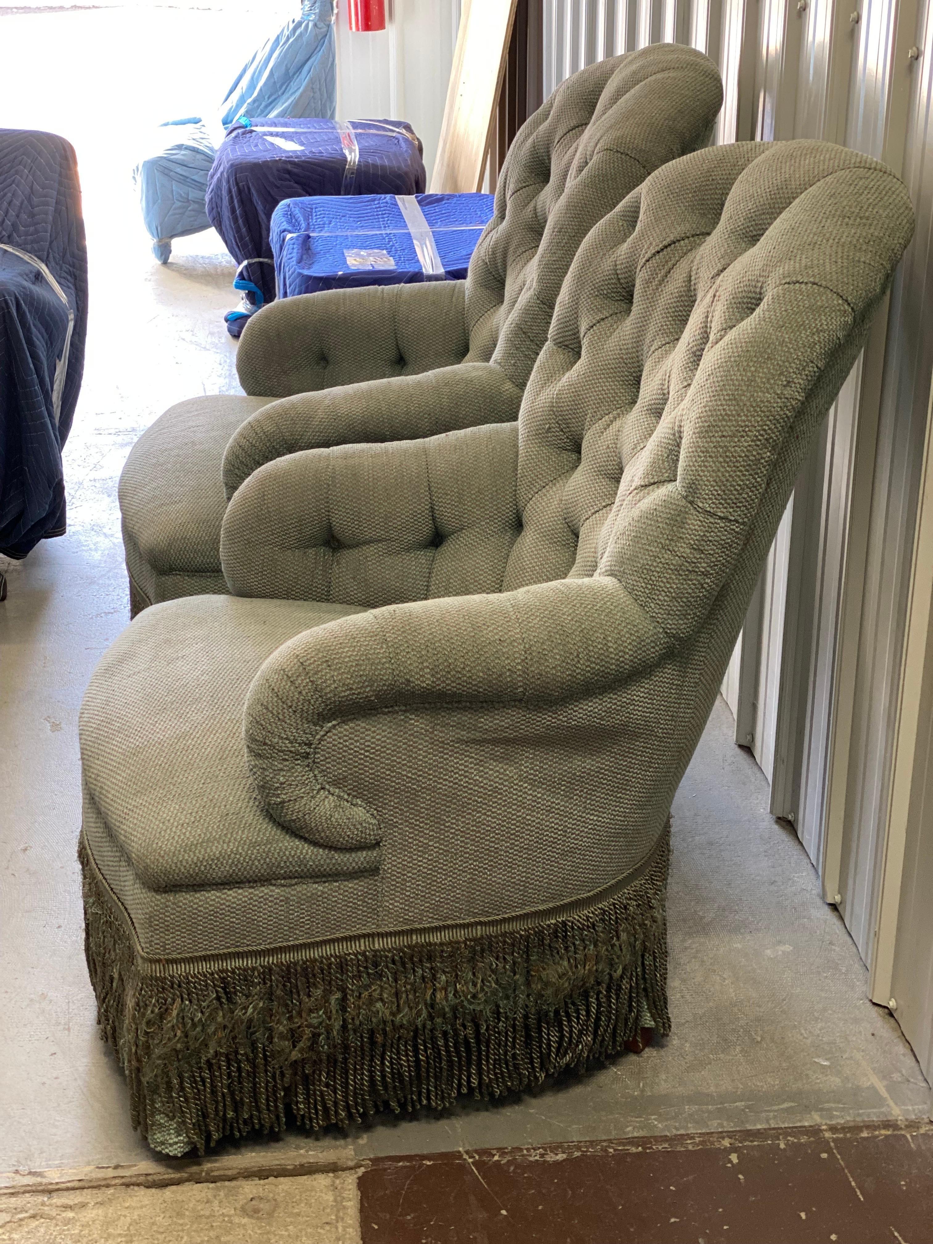Pair of Tufted Rounded Back Armchairs Custom-Made by David Easton.
Tufted, rounded back and arms, tight seat with long bullion fringe. Classic form. Chenille and bullion fringe in poor condition. Structurally sound, reupholstery needed. Cat pulls to