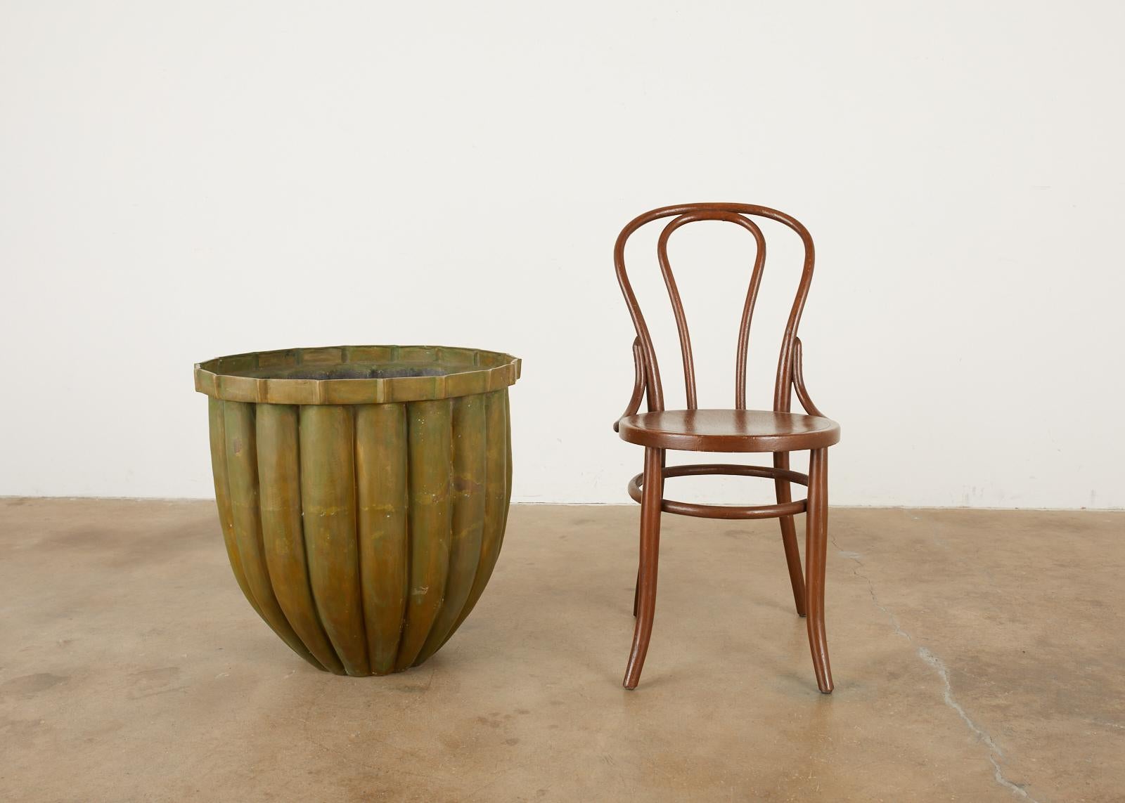 Matched pair of large bronze jardinières or planters having a tulip form. The tapered bodies have a fluted design with a round ring neck. The planters have a patinated finish with verdigris. Perfect for garden or entry with a rich, aged patina. From