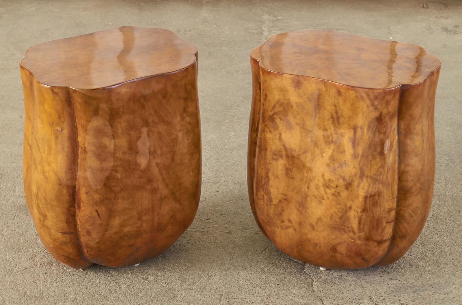 Amazing pair of wooden side or end tables having a biomorphic tulip form featuring a goatskin veneer. The subtle waisted form has ribbed sides and a flat top. The goatskin or parchment veneer has a rich patina with a Fine polished finish. Very