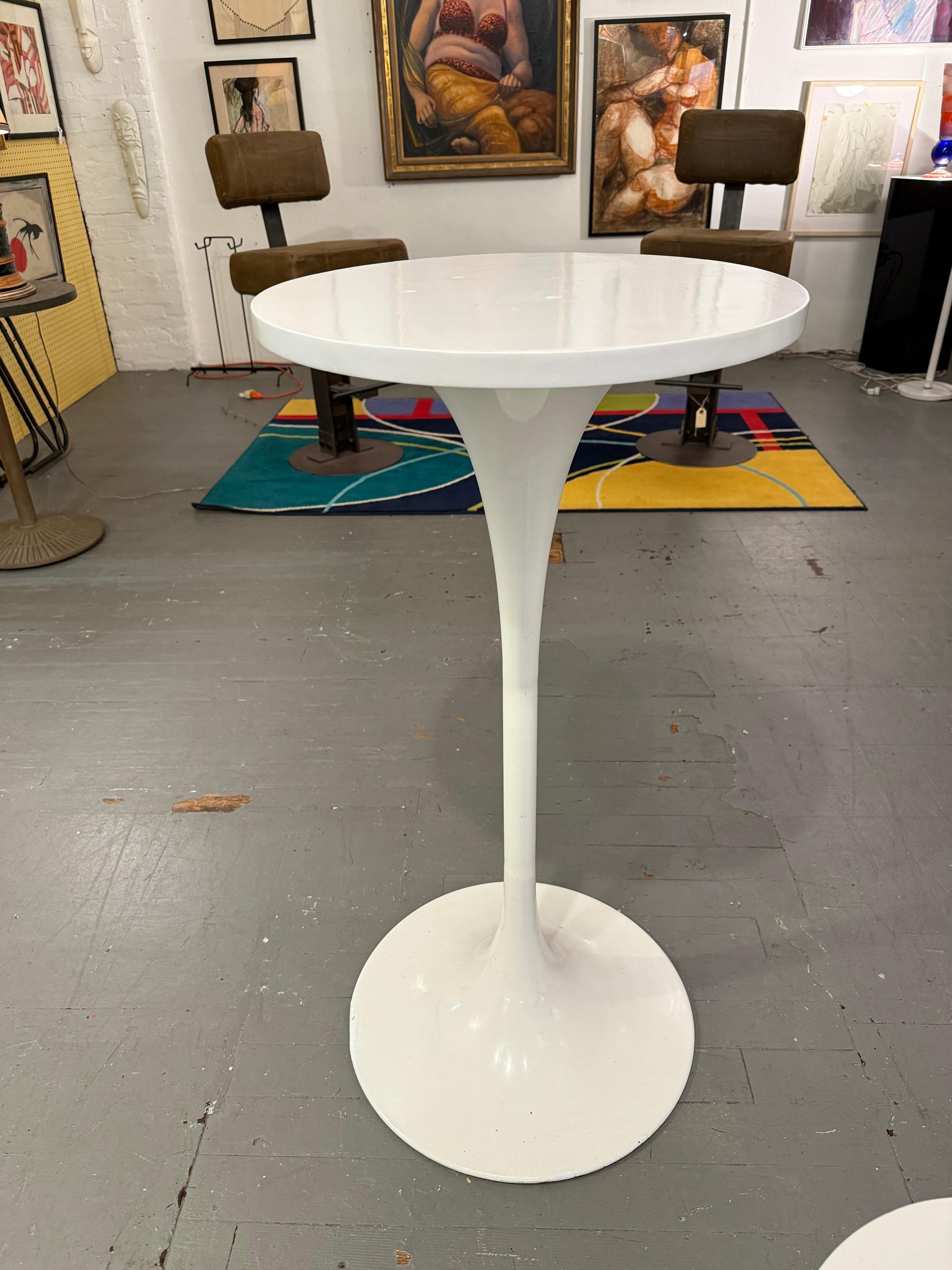 Inspired by the iconic silhouettes of mid-century European design, these pedestal accent tables feature slender stem-like bases that flare elegantly into circular tops. Their glossy white surfaces reflect light softly, emphasizing the fluidity of