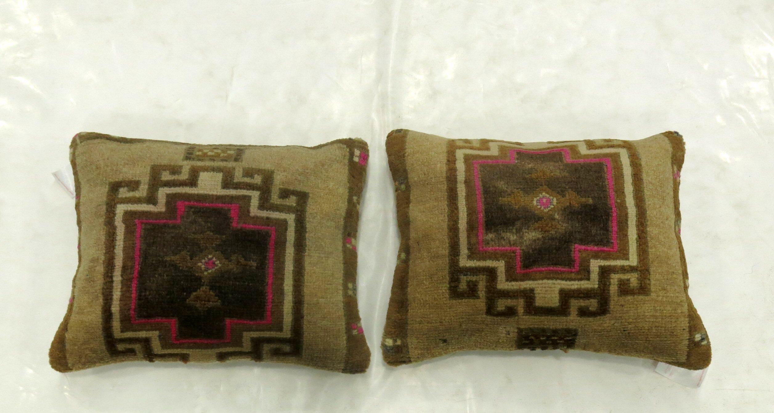 Two pillows made from a Turkish rug with pops of pink. Measuring 16