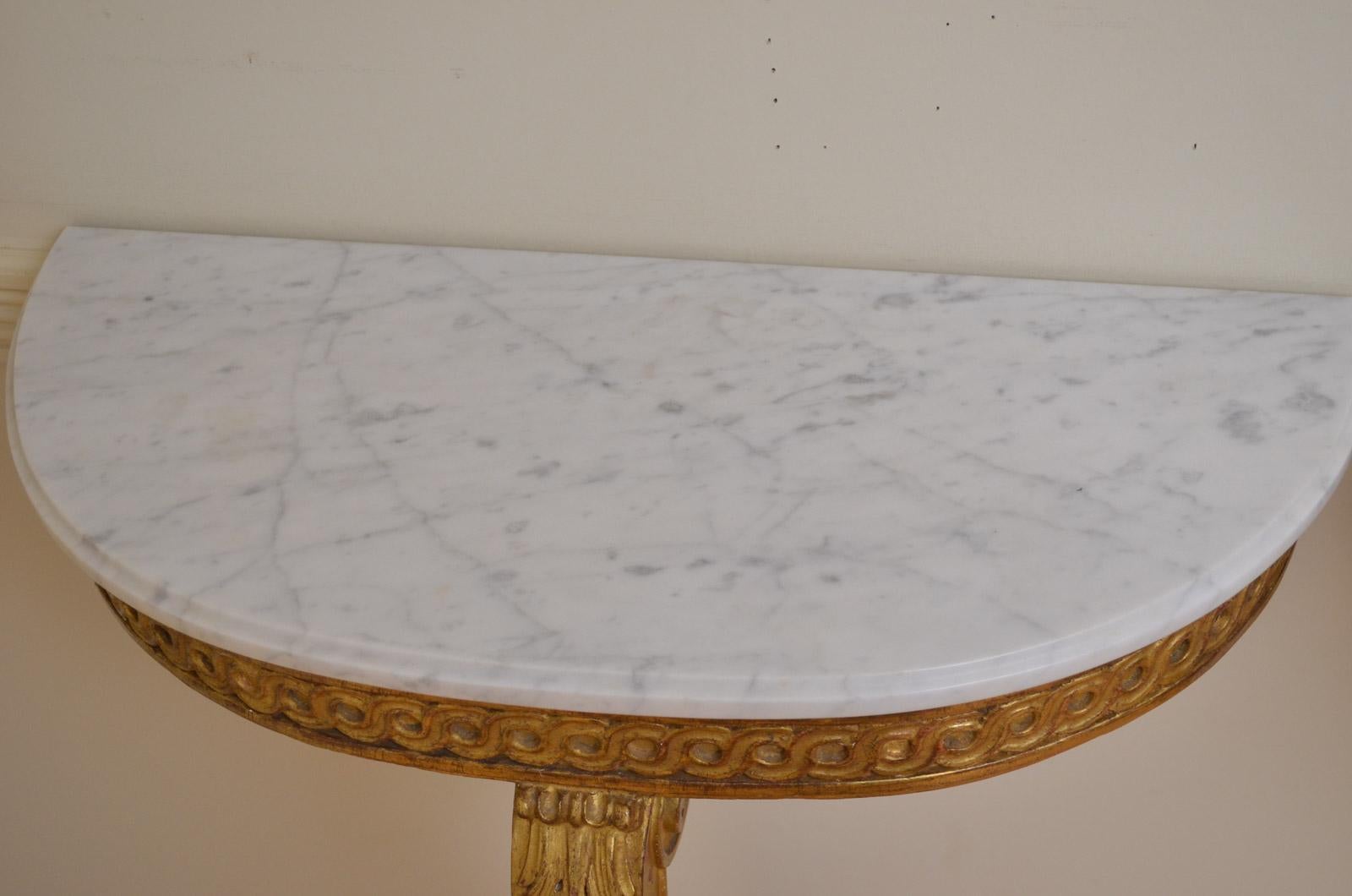 Sn4350, pair of gilded console table of demilune outline, each having original white and veined marble top and shallow frieze and finely carved cabriole leg. This pair of antique console tables is in excellent original condition throughout, circa