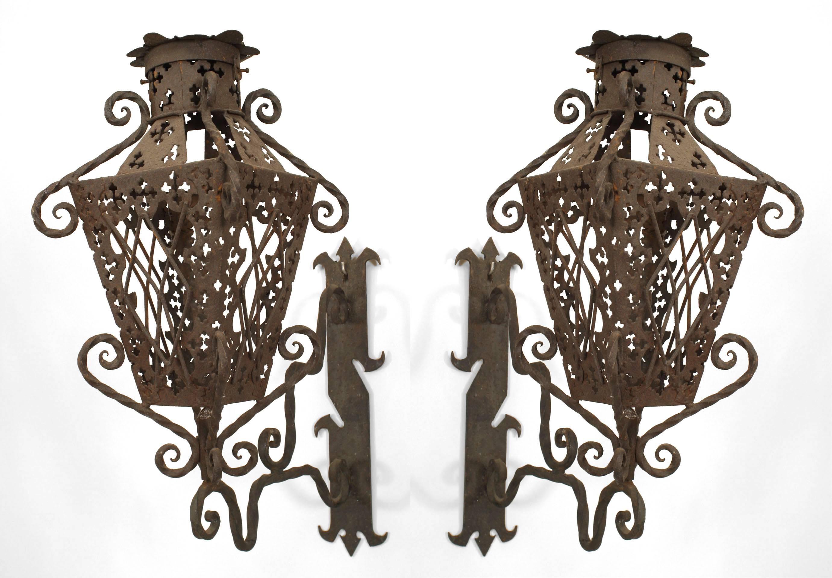 Pair of Italian Renaissance-style (19/20th Century) wrought iron exterior wall lanterns with 4 filigree panels supported by a scroll design wall mounted bracket (PRICED AS Pair).
