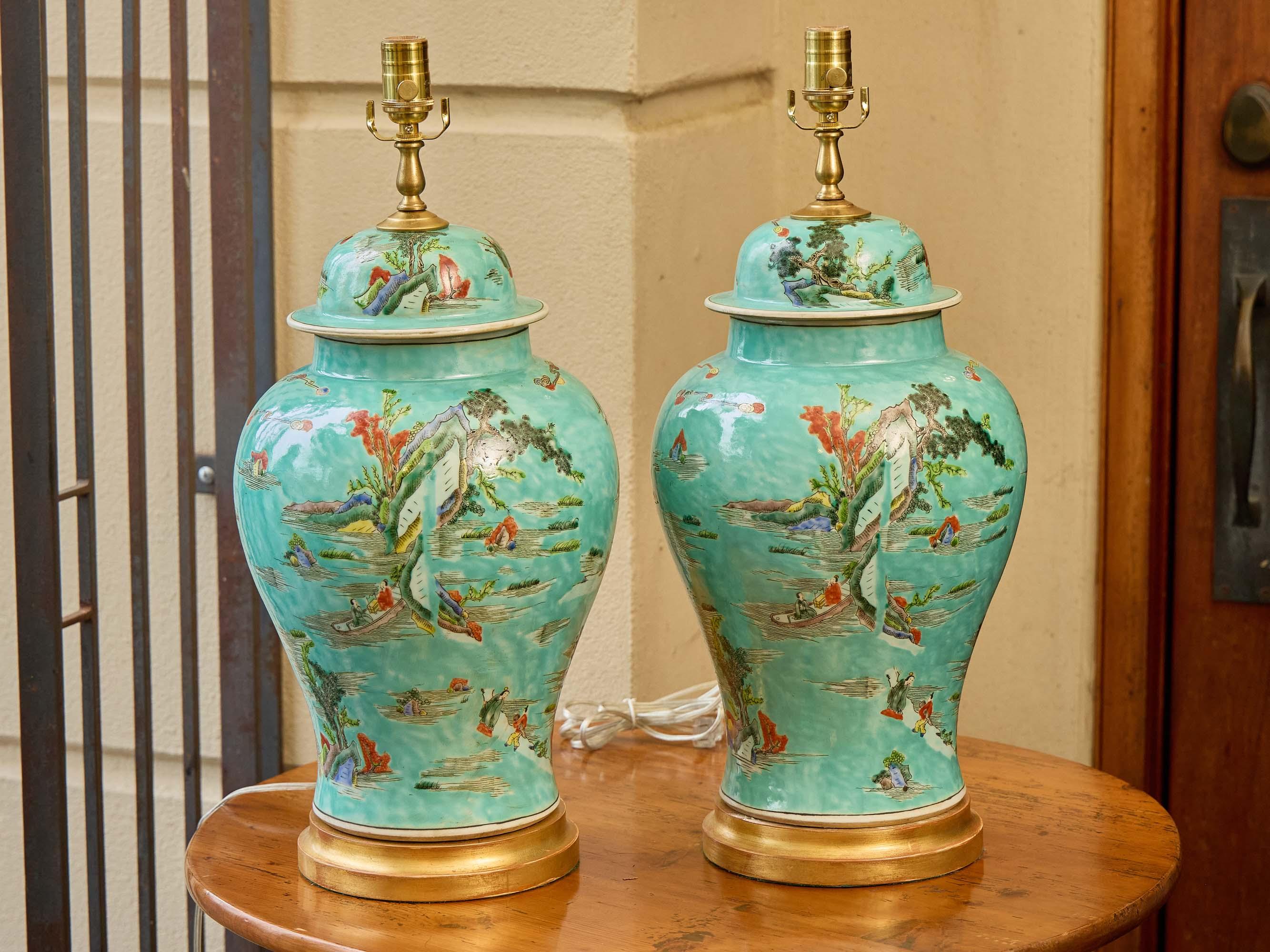 Avec leur glaçure turquoise sereine et leurs scènes lyriques peintes à la main, cette paire d'urnes asiatiques offre un moment de calme - les paysages se déploient sur la surface comme les fragments d'un rêve. Des personnages élégants se promènent