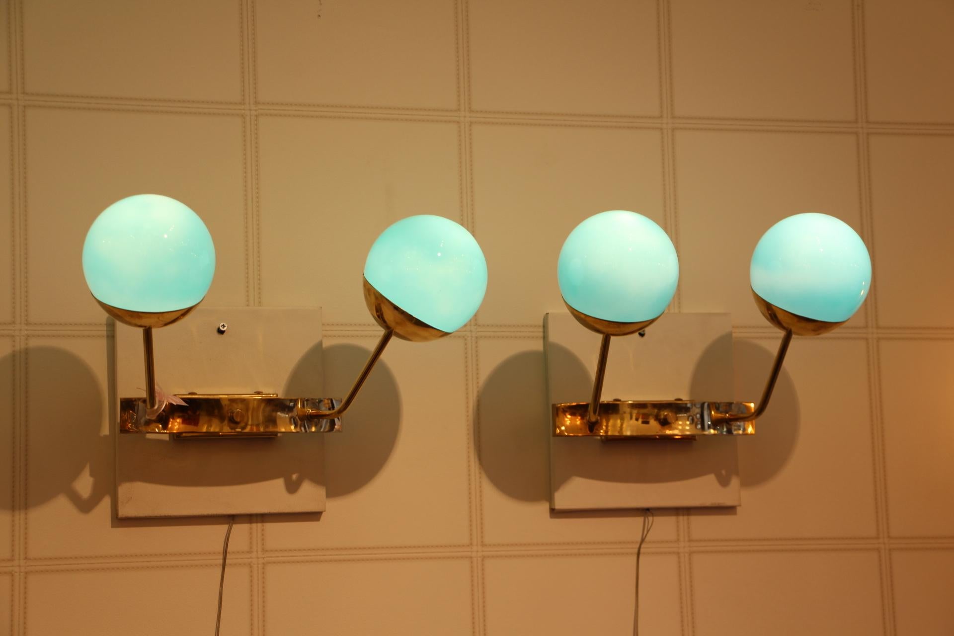 Very elegant pair of sconces in brass and 2 turquoise blue Murano glass globes.
When light is on, the globes become sky blue color.
