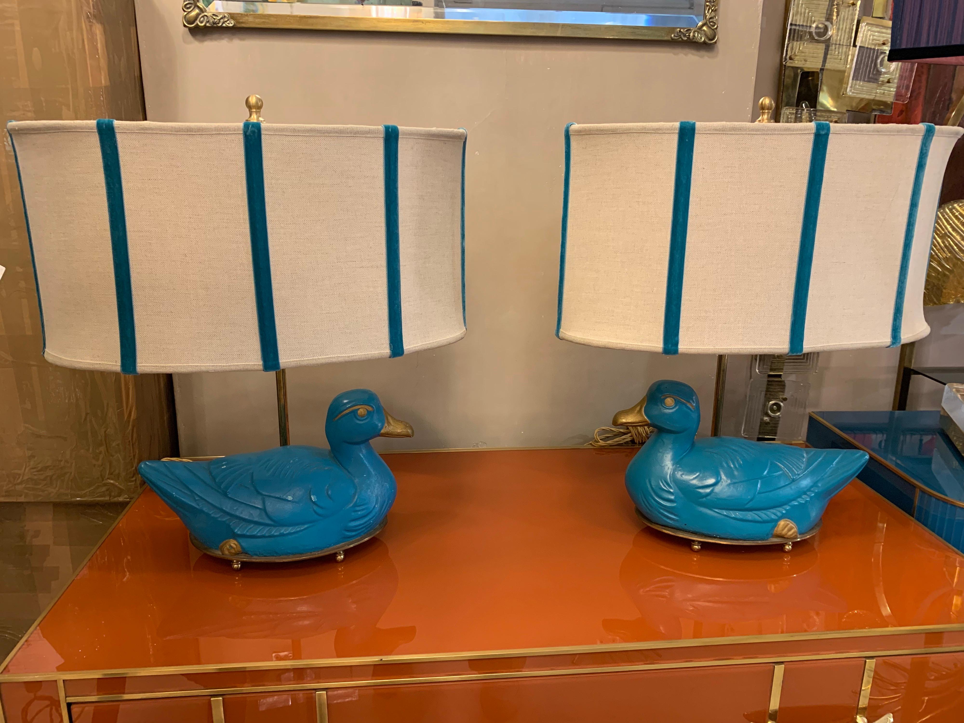 Pair of Mid-Century turquoise bronze table lamps in the shape of a duck with our lampshades, brass fittings. The duck is in bronze hand-painted in turquoise and gold and fixed to an oval brass structure.
The oval lampshades are hand-sewn and