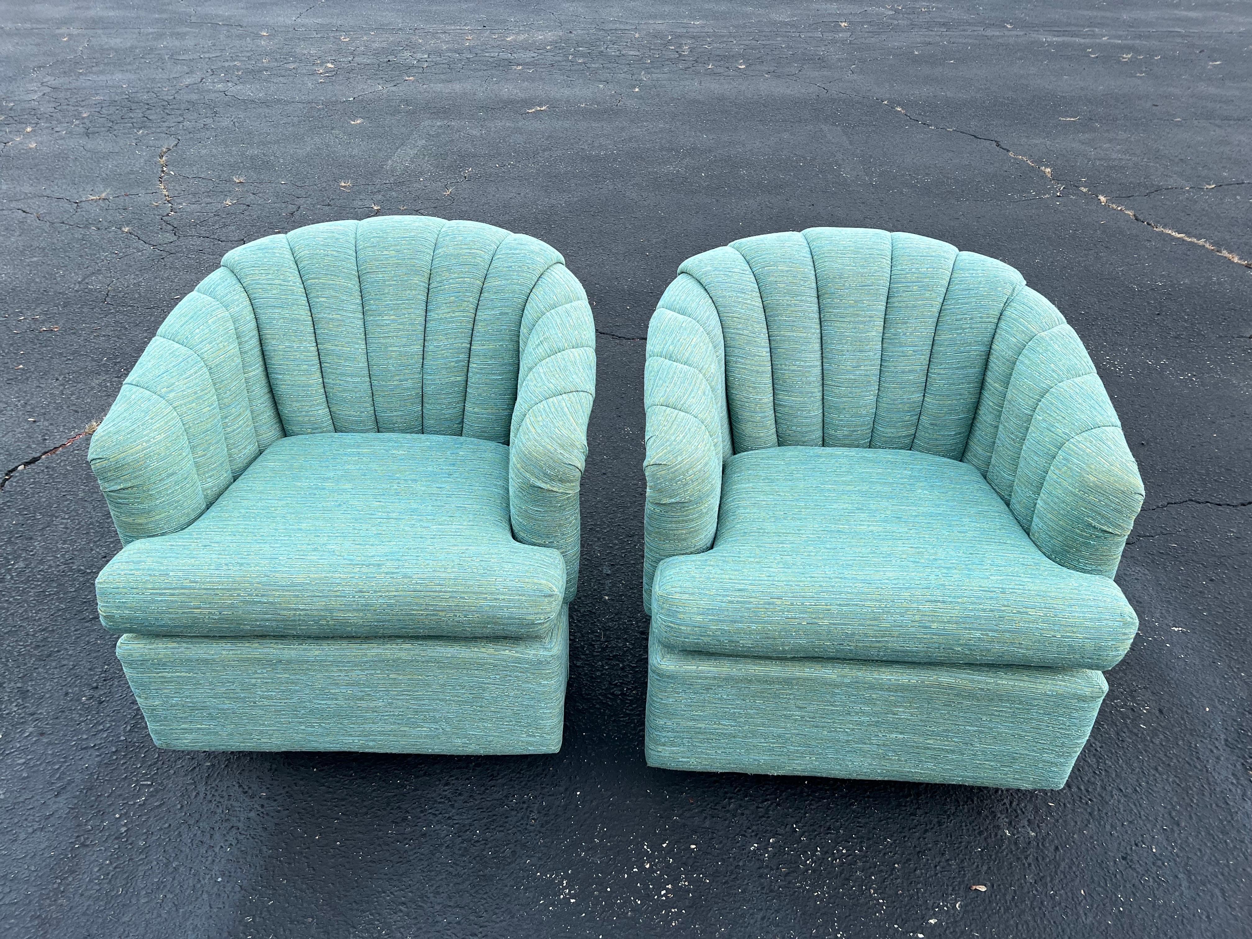 Paar türkisfarbene Kanalrücken-Drehstühle. Diese Stühle sind drehbar und wippbar und haben einen runden Metalldrehfuß. Die Polsterung hat einen mehrfarbigen gewebten Look mit einem cremefarbenen Hintergrund. Diese Stühle sind von Best Home