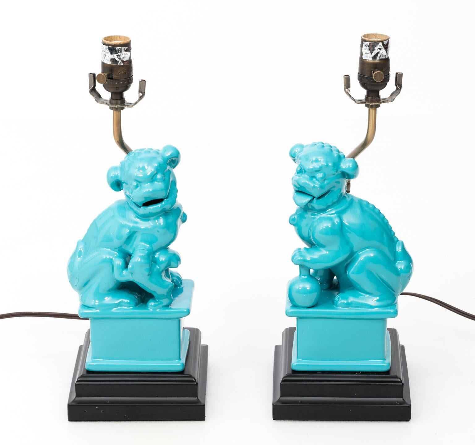 Pair of turquoise foo dog lamps with shades.