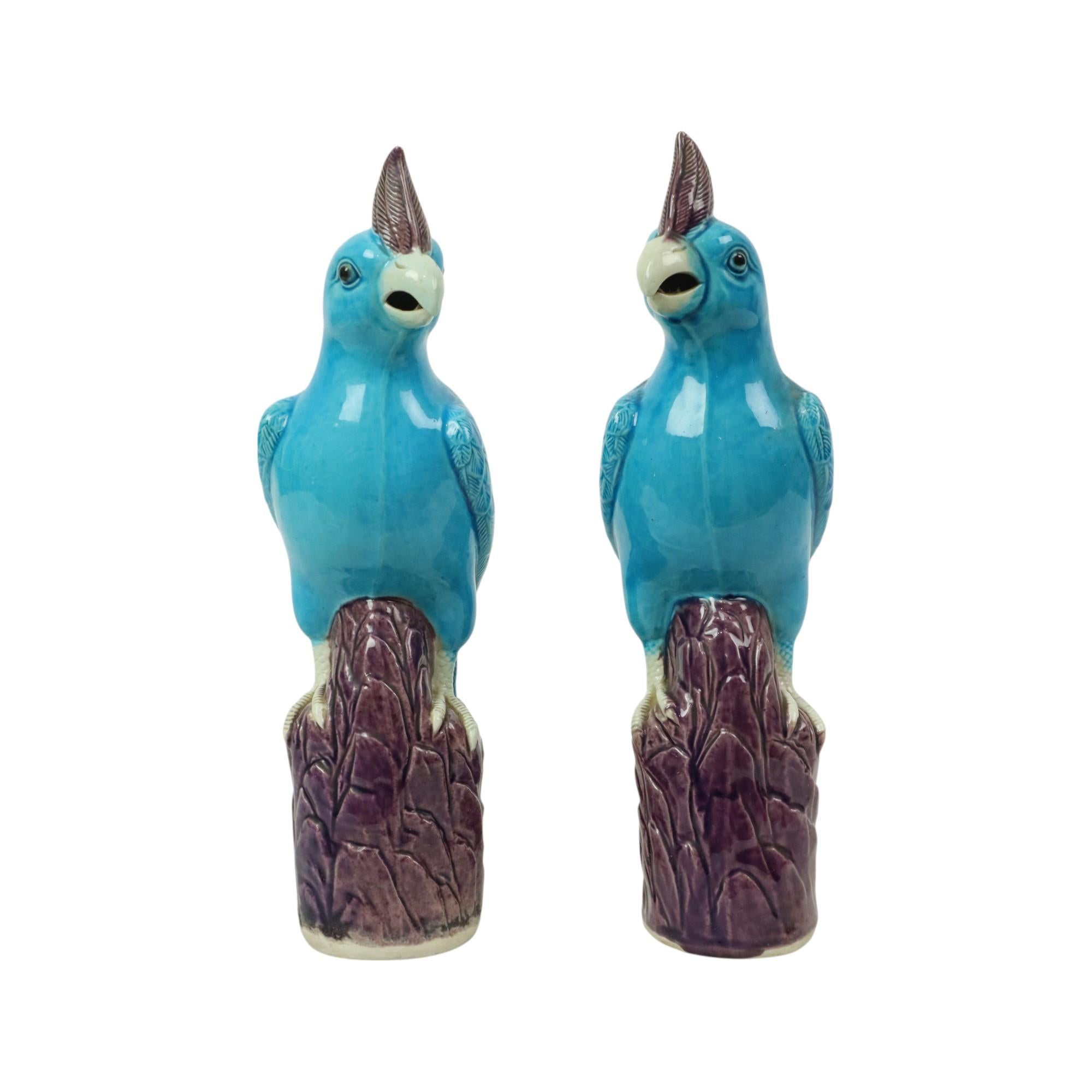 Rare pair of parrot or cockatoo figurines, made of blue or turquoise and purple glazed Chinese porcelain, circa the first half of the 20th century. Marked on the bottom with the maker's stamp in relief. These are based on an antique example.

These
