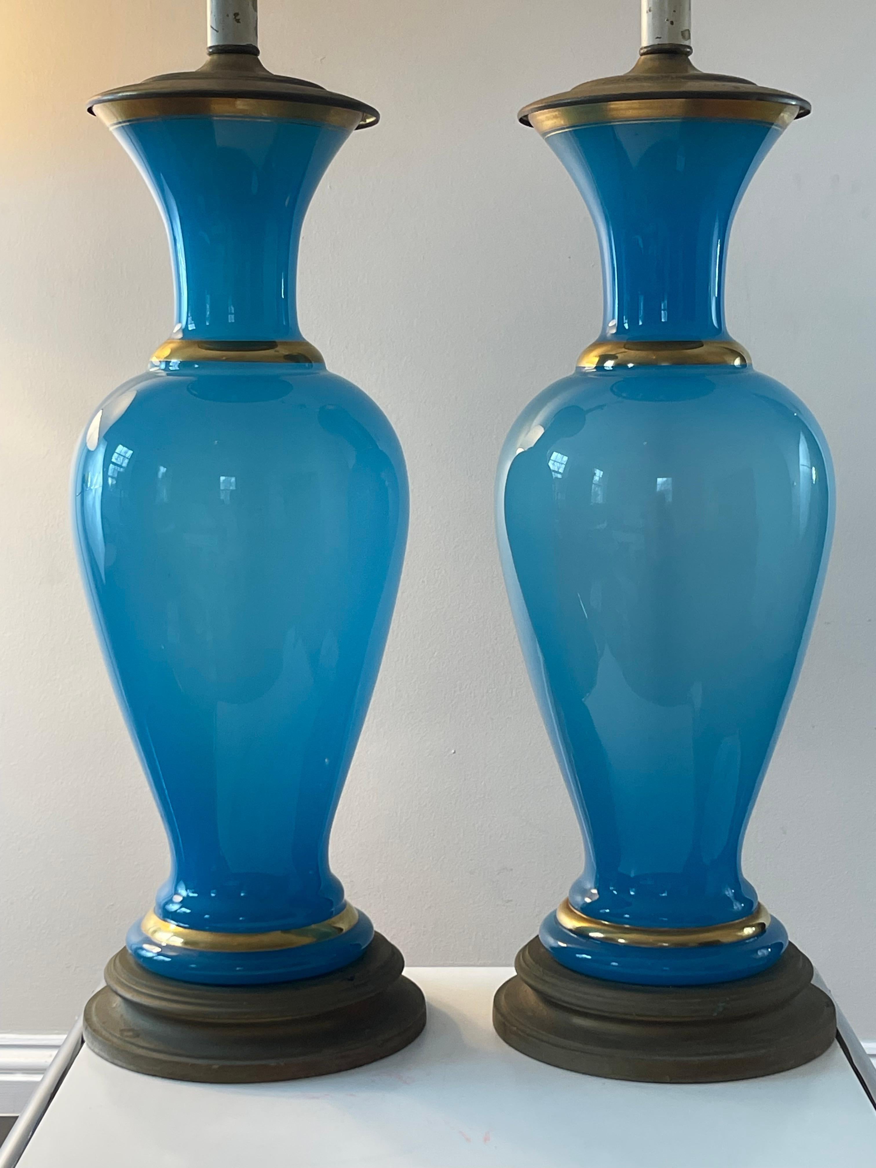 Serene turquoise glass lamps in French opaline with gilt detailing. Lamps are in working order but rewiring is recommended. Please note: glass body measures 19.5” in height; lamp measures 43” to top of finial.