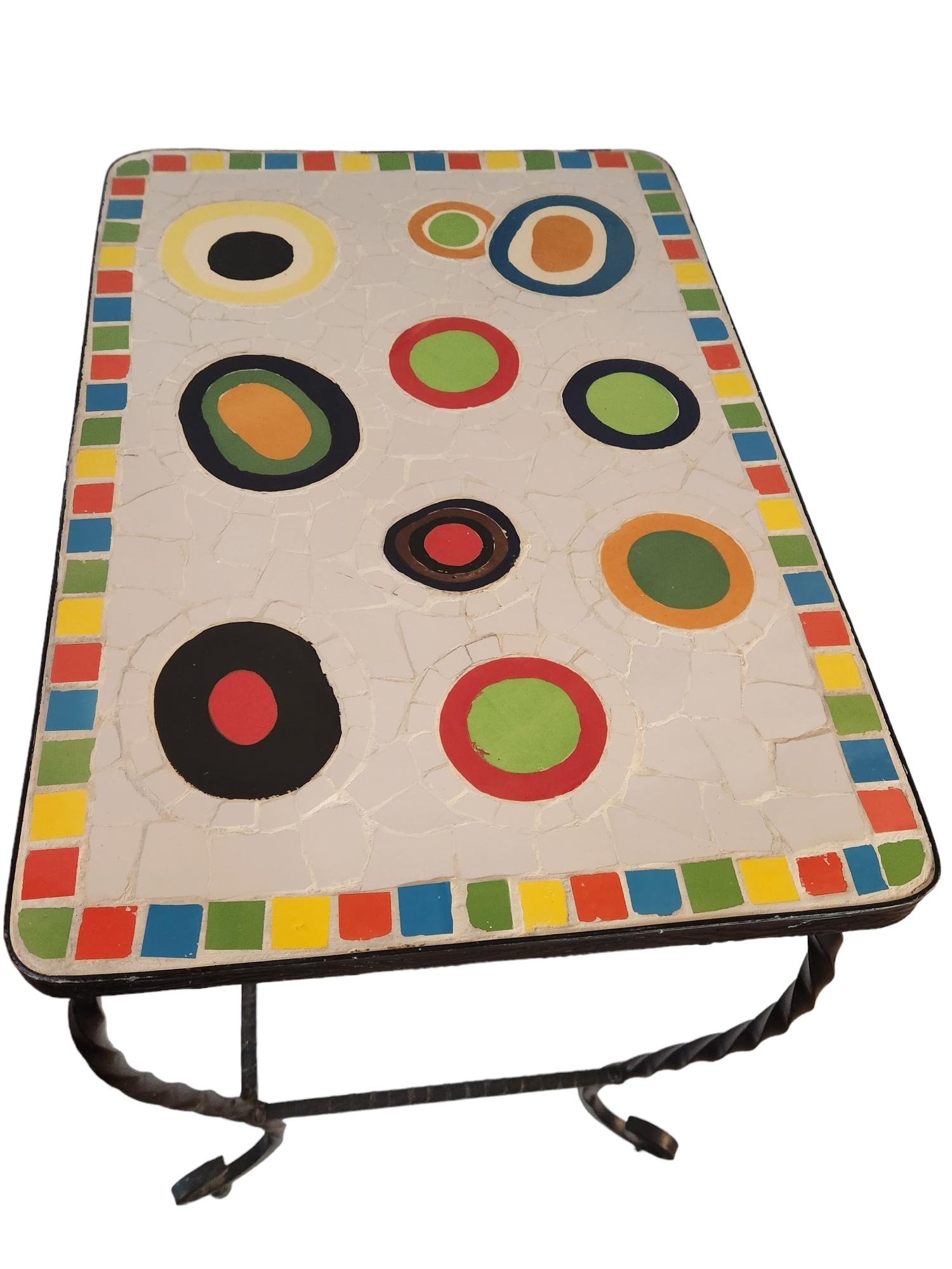 Two outdoor garden tables the frames are constructed of twisted wrought iron.
The tops are bordered in squares of colored tiles with colorful circles of ceramic surrounded in assorted shapes of white tile.
The tables are in good condition.
Tables
