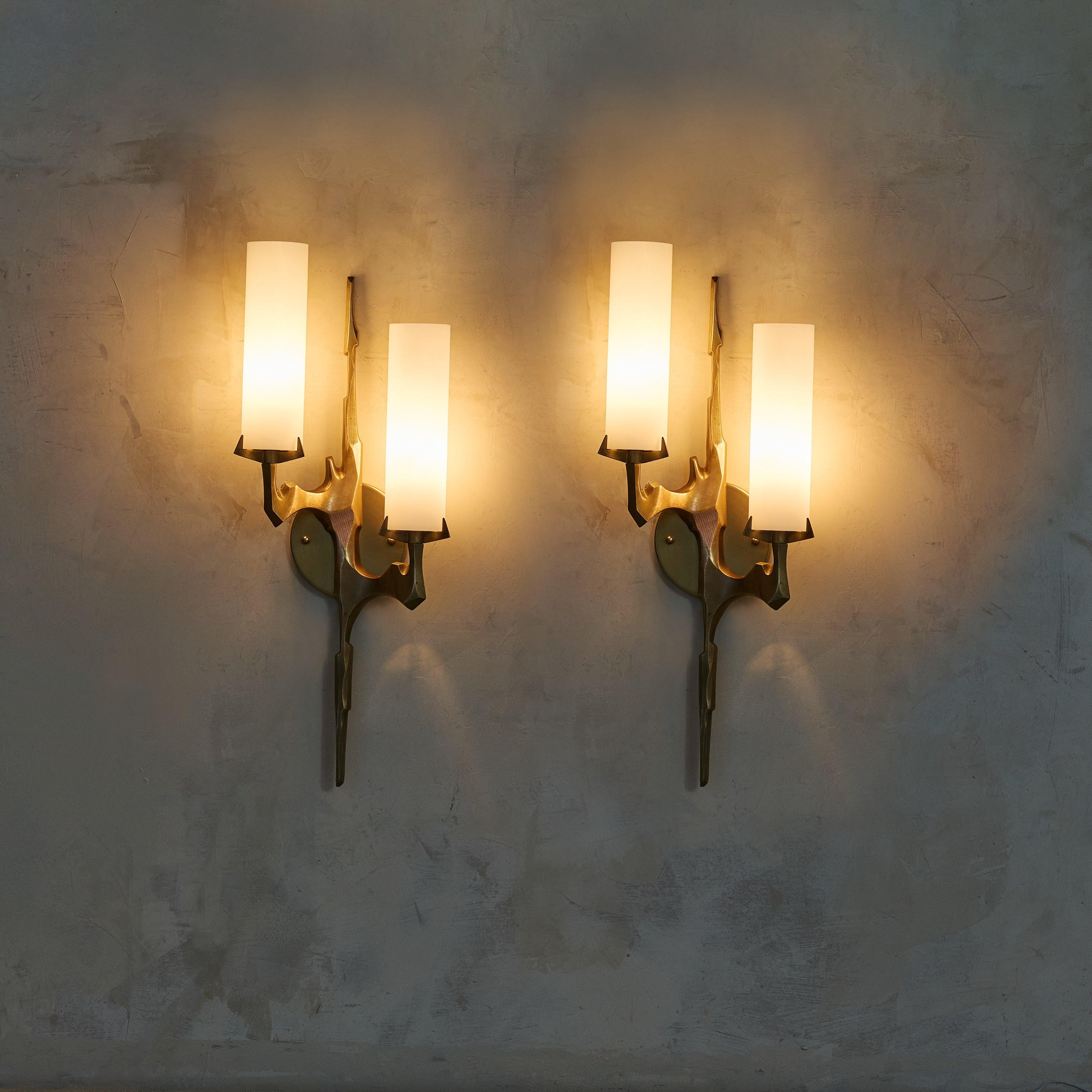 A pair of French sconces designed by Felix Agostini for Maison Arlus in the 1960s. These sconces, crafted from cast gilt bronze, feature two-arm silhouettes meticulously shaped into stylized branches. The organic form of the branches is enhanced by