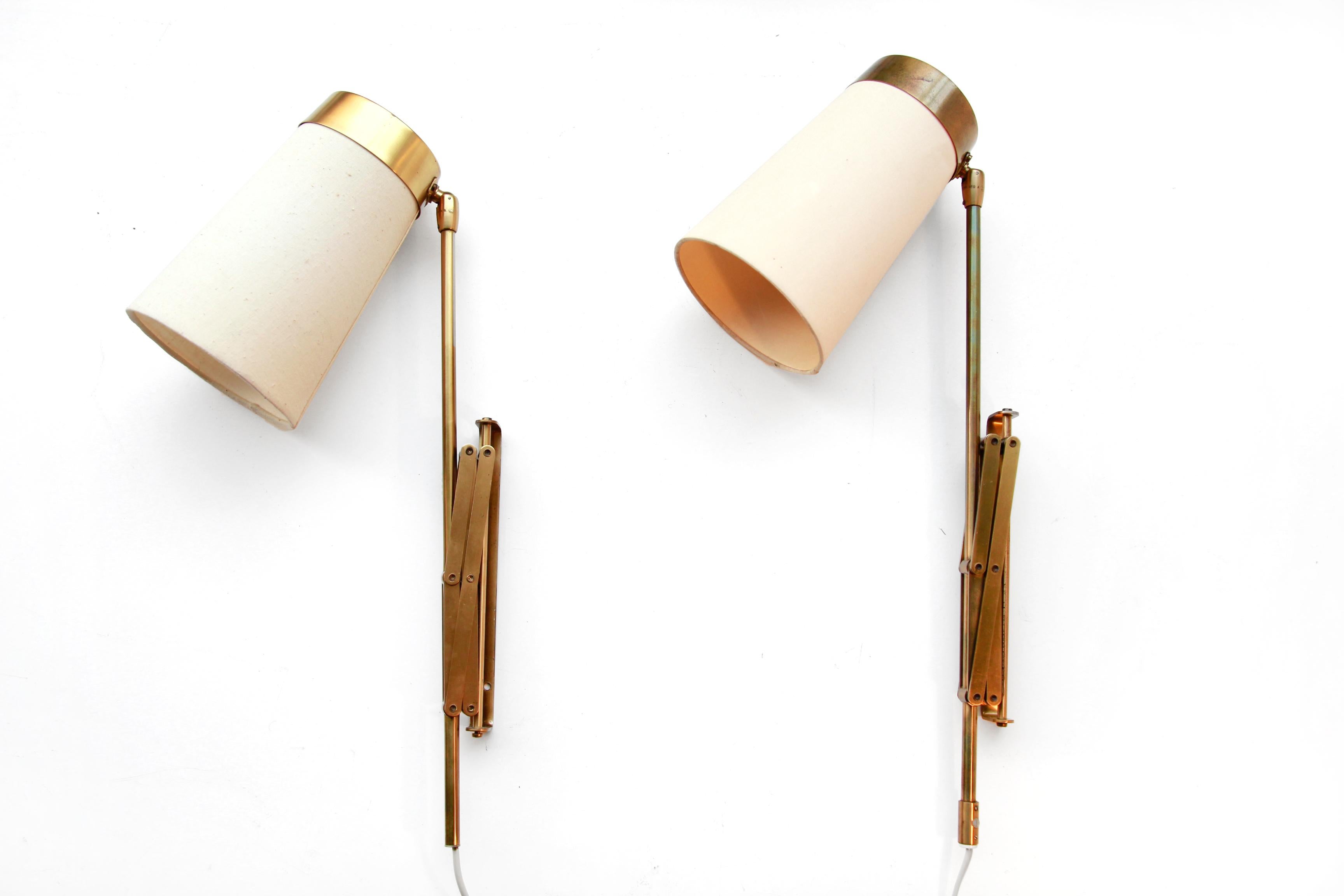 Beautiful rare set of two brass wall lamps by T.H. Valentiner from Denmark. The cleverly designed scissor mechanism allows the fabric lamp shade to be directed in all directions and pushed to the front and back. This lamp is made of brass and would