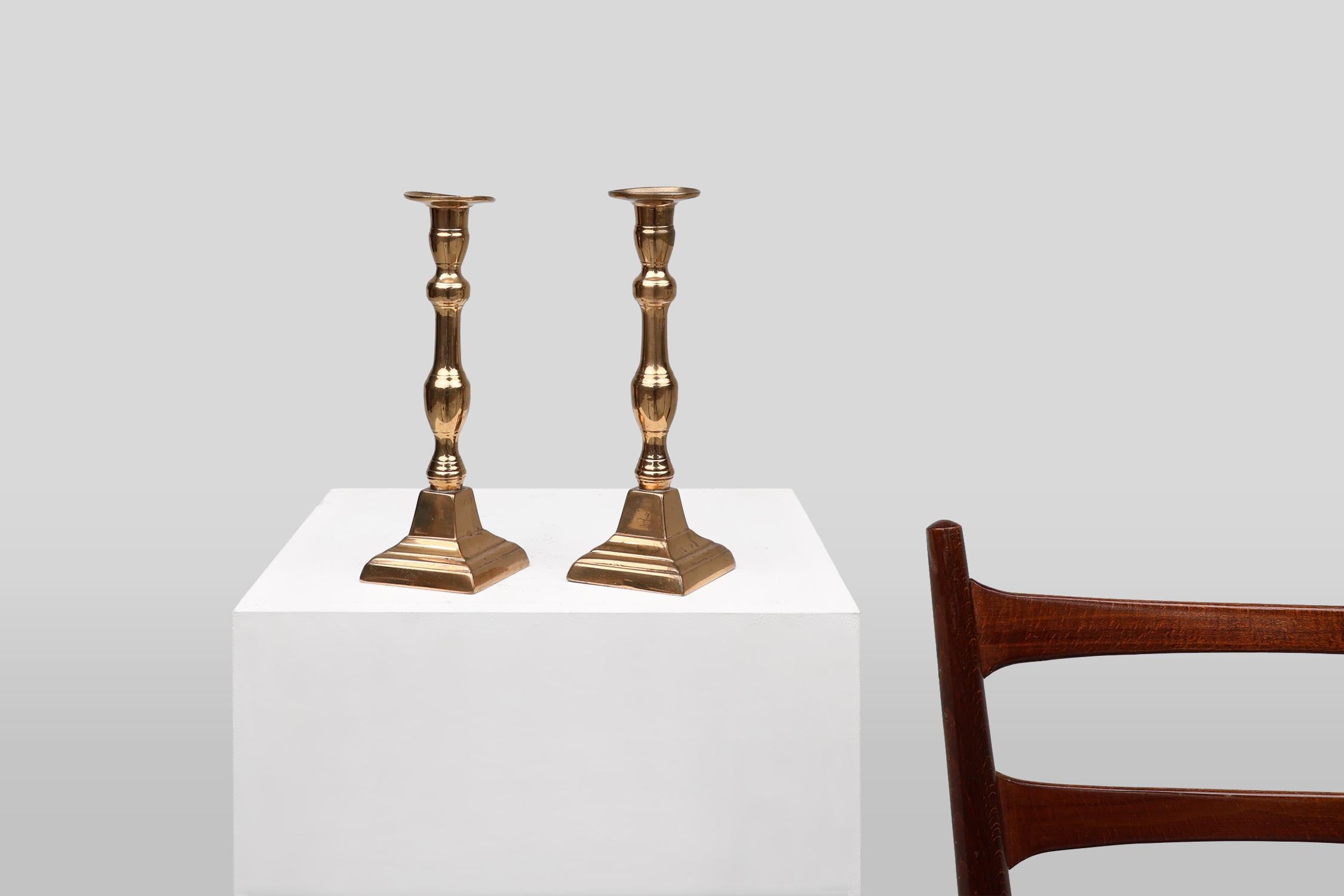 Un set di due eleganti candelieri in rame con base quadrata. Realizzato in Francia intorno al 1900. 

Questo bellissimo set dal design classico si integra perfettamente con l'estetica moderna e tradizionale.