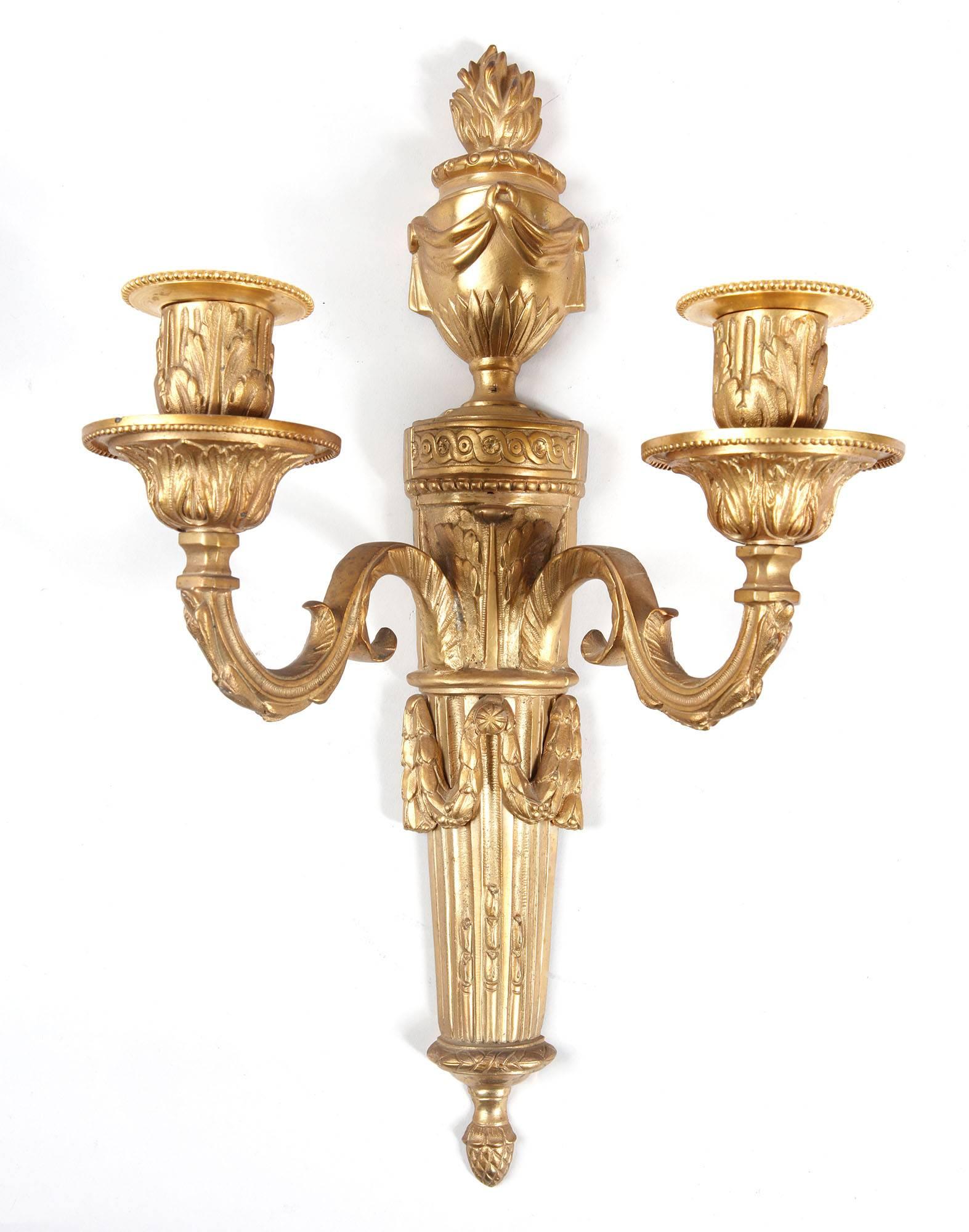 A pair of two-light flaming urn wall appliques
France, circa 1900

Measures: 42 cm high, 24.5 cm wide.