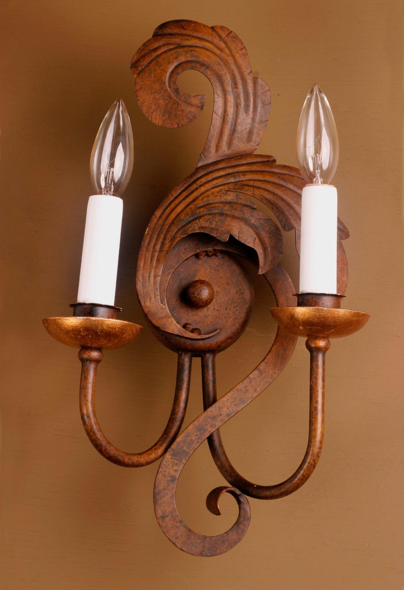 This beautiful pair of Italian sconces are made of burnished iron and tole, each featuring a pair of bobeches with real gold leaf. The craftsmanship in the flowing scroll work shows a detailed sense of balance and movement.

Each piece in our shop