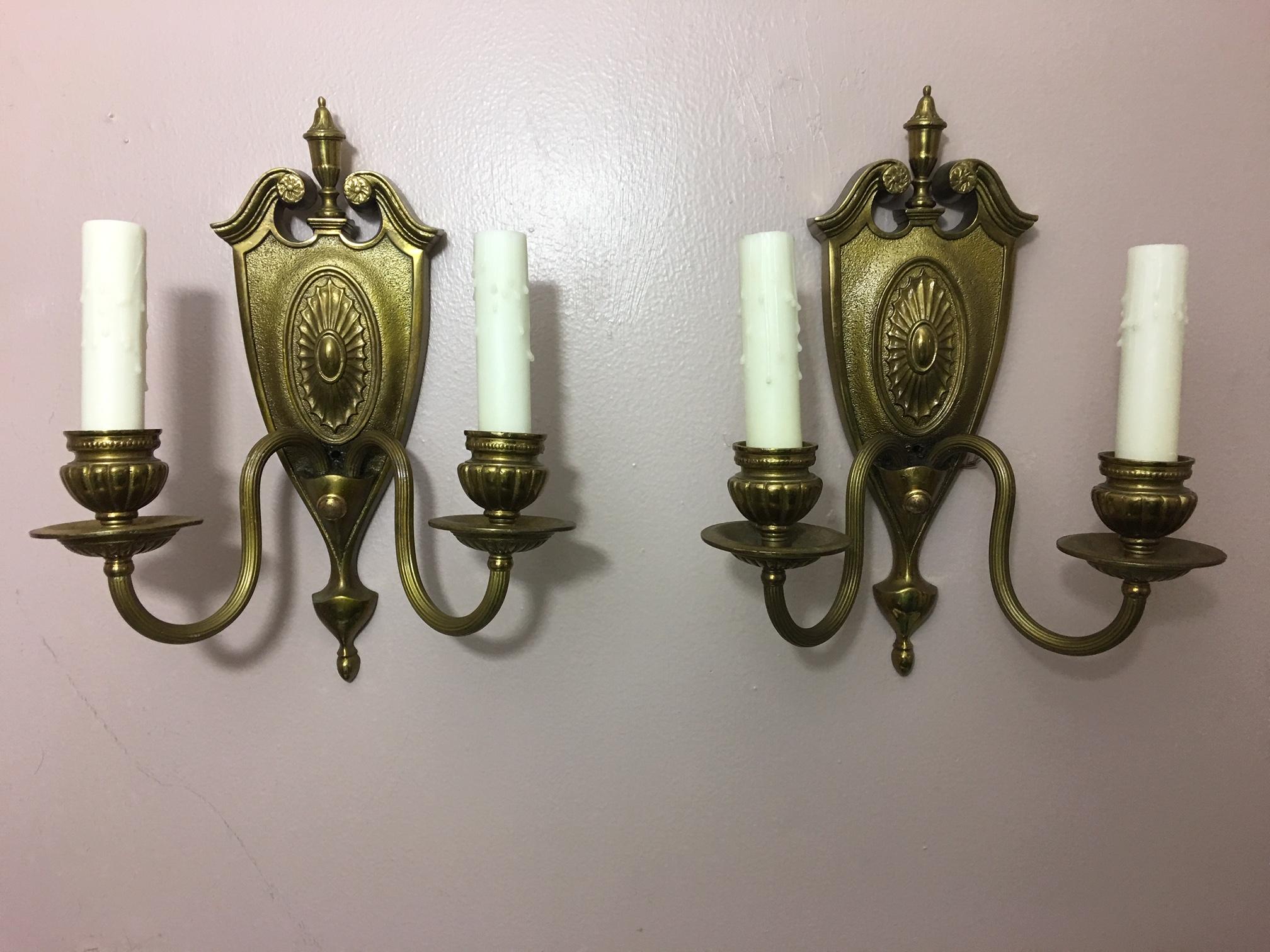 Pair of two-light shield back brass sconces, 20th century.