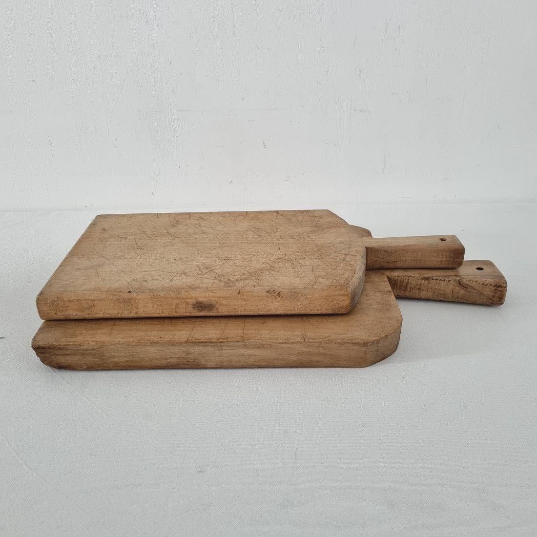 Beautiful pair of two wooden chopping-cutting boards. Great statement on your counter-top,
France, circa 1850-1900. Weathered. Measures: H:41-46,5cm W:20-25,5cm D:3cm 
If needed items are treated against woodworm.