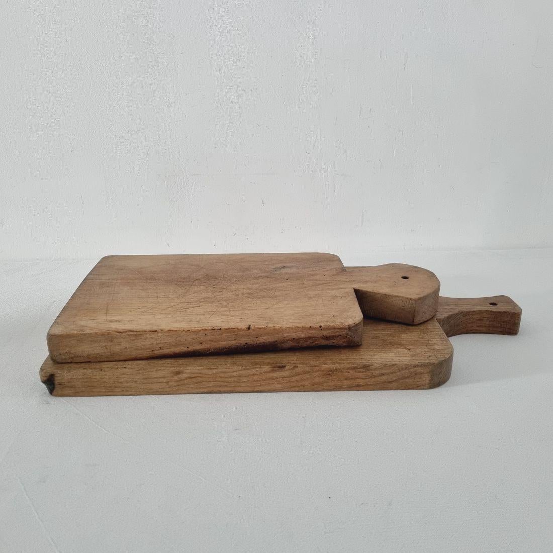 Beautiful pair of two wooden chopping-cutting boards. Great statement on your counter-top,
France, circa 1850-1900. Weathered. Measures: H:45,5-58cm W:25-30cm D:3,5-4cm 
If needed items are treated against woodworm.