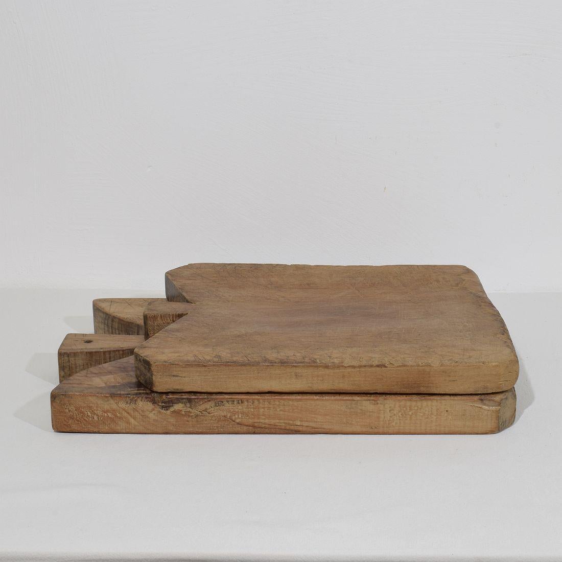 Beautiful pair of two wooden chopping-cutting boards with a nice patina. Great statement on your counter-top,
France, circa 1850-1900. Weathered. Measures: H:41-50,5cm  W:30-33cm D:3,5-4,5cm 
If needed items were treated against woodworm.