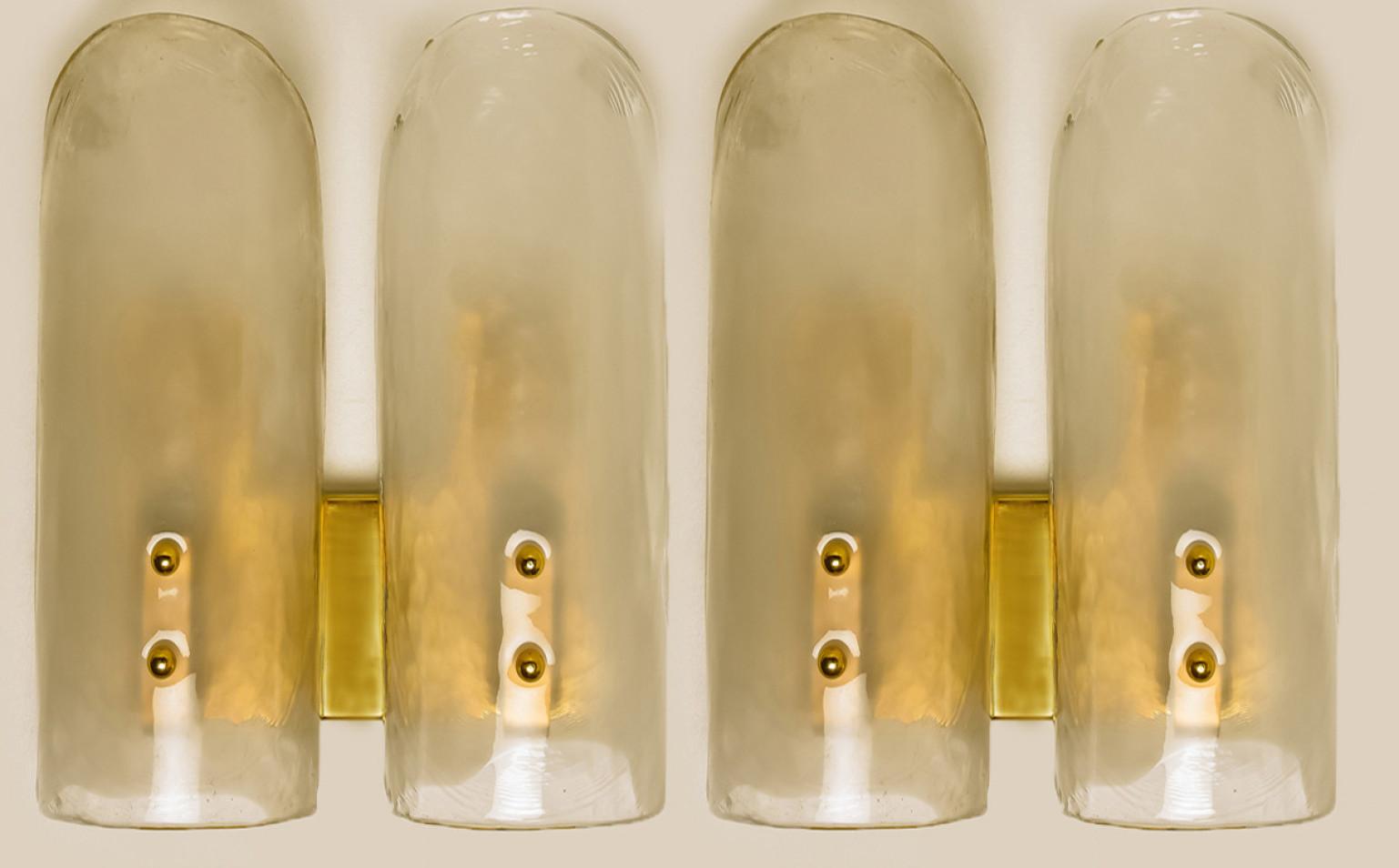 High-end wall sconces made of blown clear and opal murano glass on a messing hardware. Designed and produced by J.T. Kalmar, Austria in the 1960s. Minimalistic design executed with a taste for excellence in craftsmanship. These are real statement