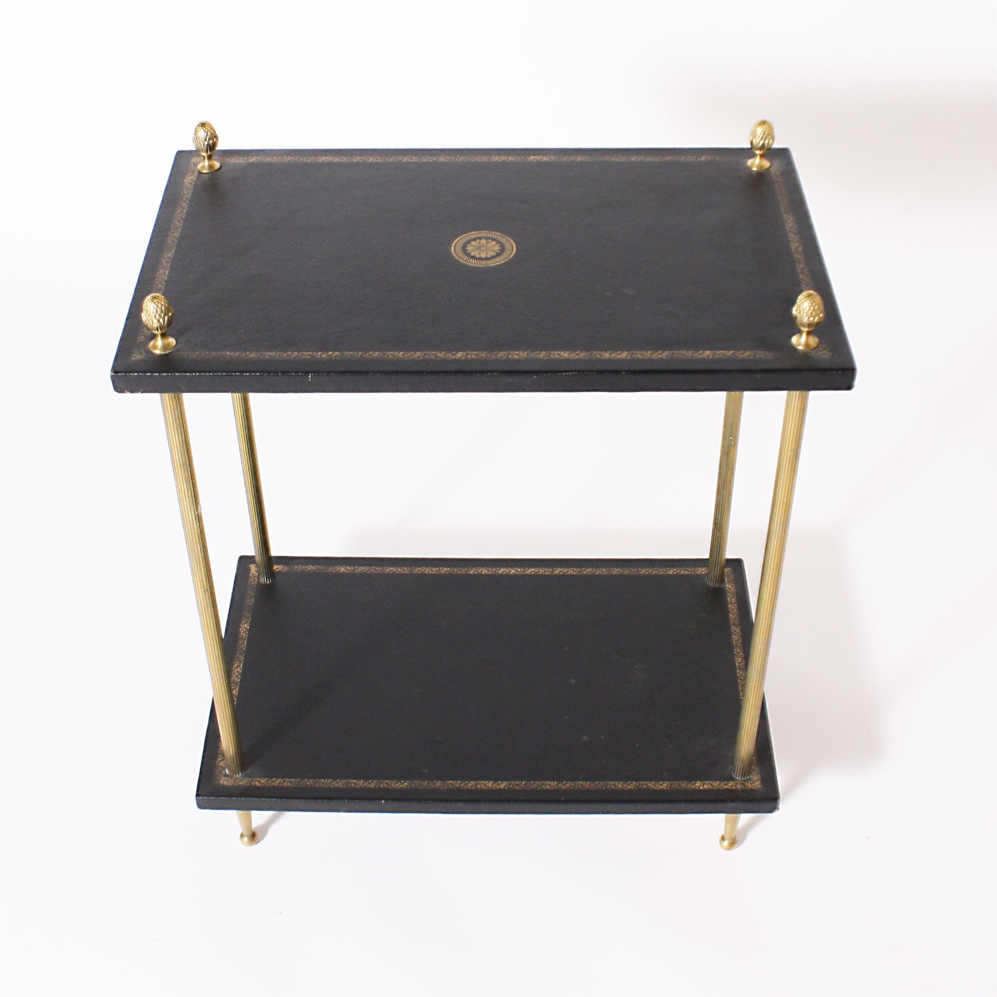 Pair of two-tier brass and leather side tables, circa 1950.
   