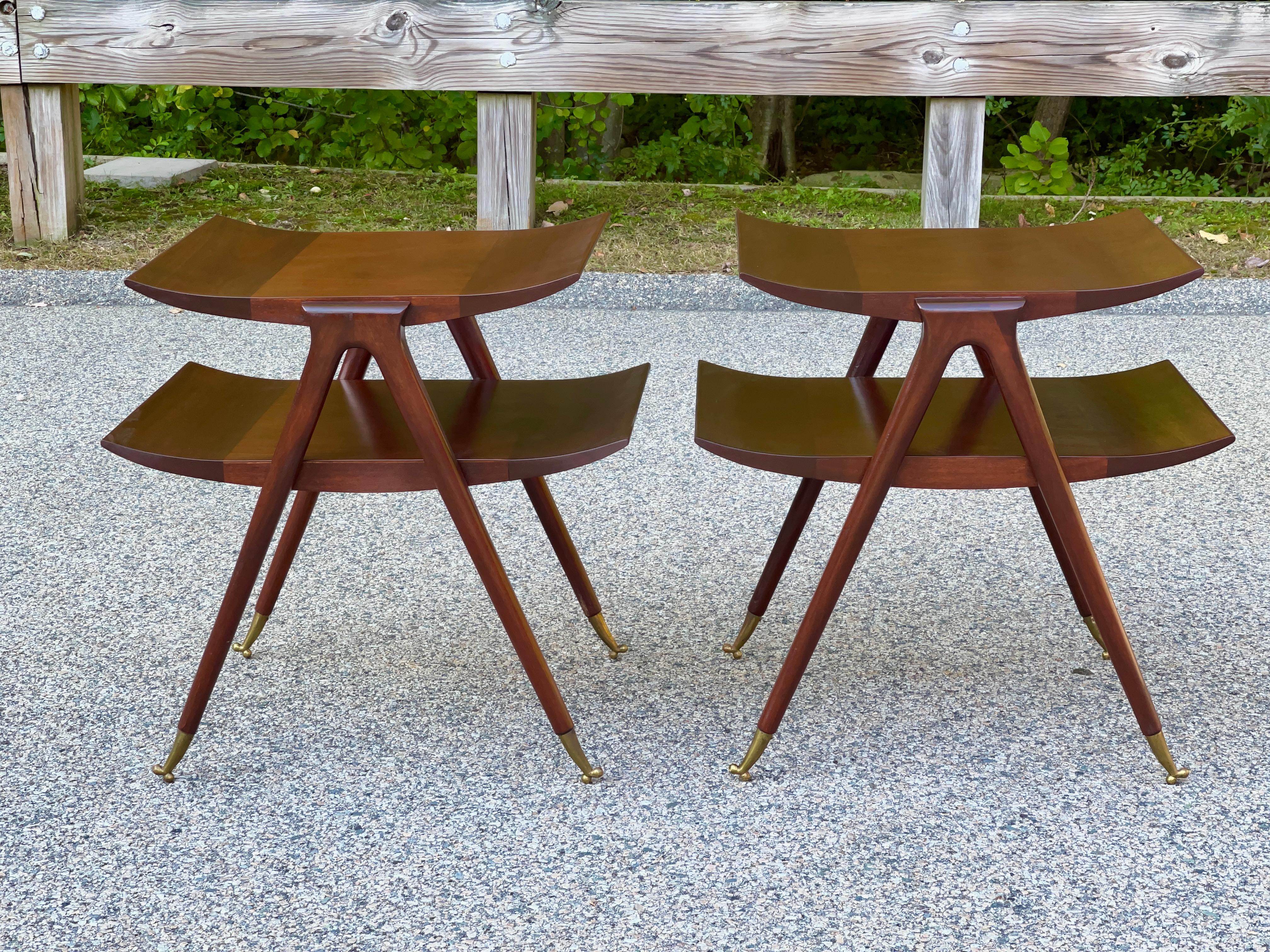 Dramatic vintage pair of bi-level tables in the style of Ico and Luisa Parisi. 
Finely constructed of mahogany hardwood and veneer, both tiers feature upswept ends and are supported by strikingly elegant tapered legs which stand on dainty solid