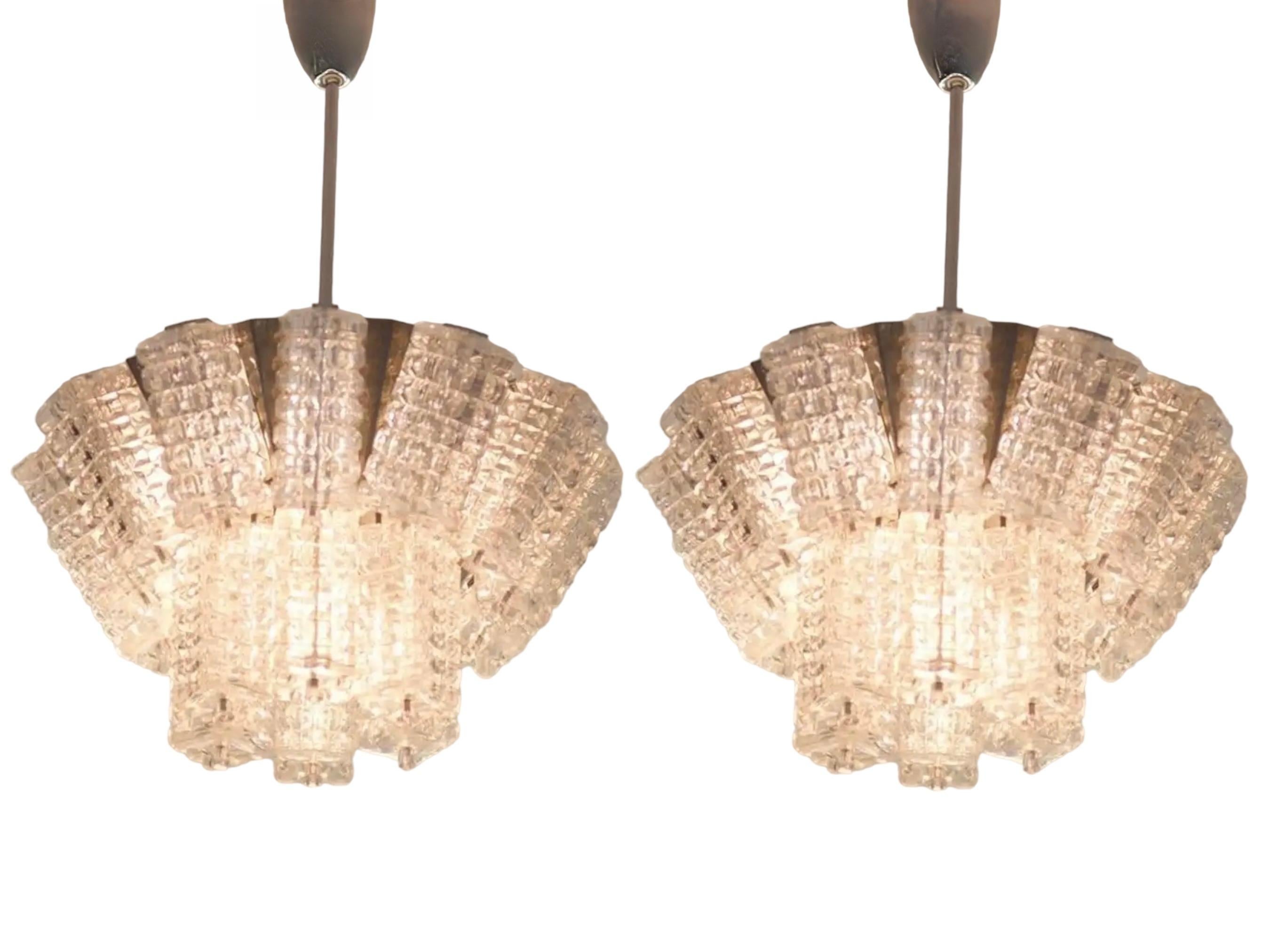 A beautiful pair of Austrian chandeliers by Austrolux, Vienna, manufactured in the mid-century, circa 1960s (late 1960s or early 1970s). Each lamp consists of a silver-colored metal frame containing triangular chrome-plated or nickel-plated elements
