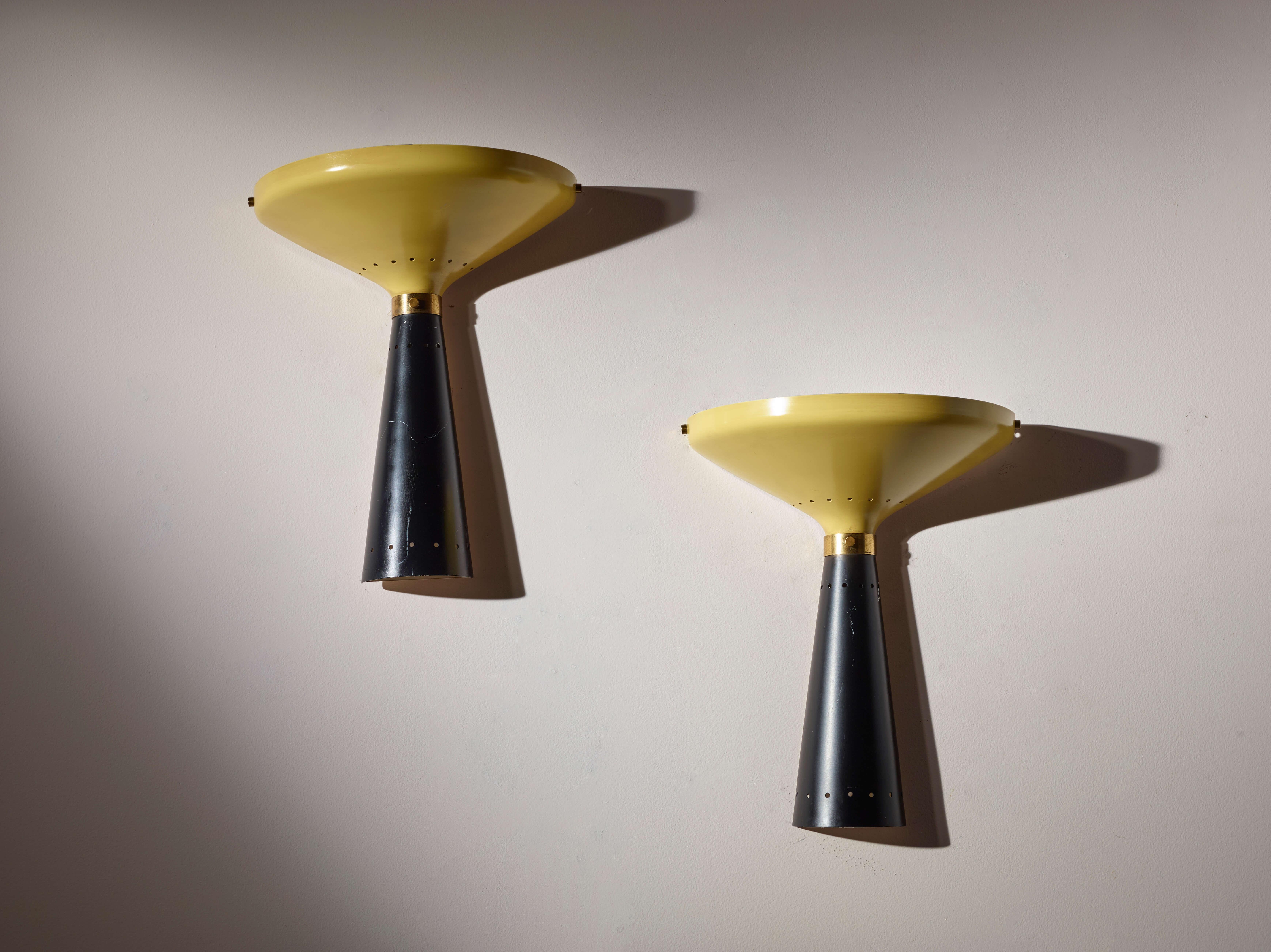 A beautiful pair of two-tone wall lights in enameled metal and brass, Stilnovo production, 1950s.

Yellow and black combine seamlessly in this two-tone 1950s aesthetic, which boldly embraces color and daring new shapes. Depending on one’s