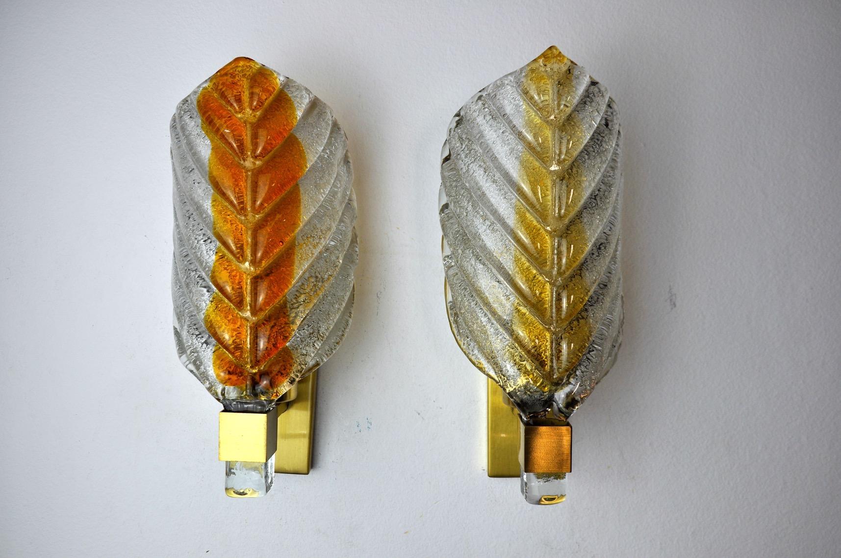 Superb and rare pair of leaf-shaped sconces, designed and produced in murano, italy, in the 1970s. Both crystals have a distinct orange tone. The sconces are of a gold metal structure and leaf-shaped frosted glass. The diffused light is soft and