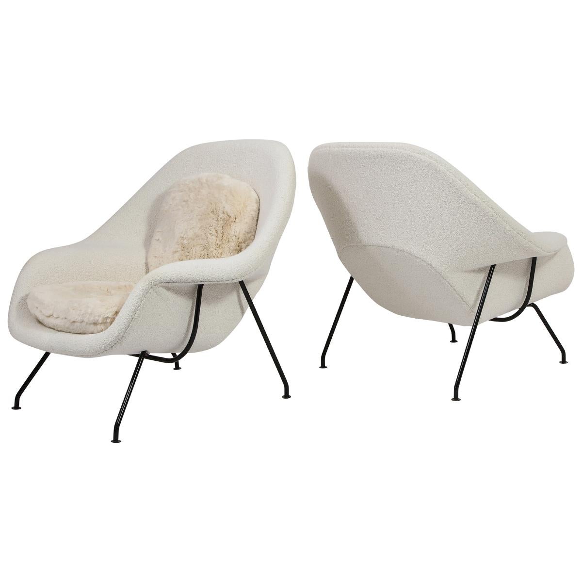 A pair of the Classic womb chairs designed by Eero Saarinen with matching ottomans upholstered in bouclé and faux fur. These are early examples stamped 1955 and 1954 respectively.

The price is for the pair. Can be sold separately upon request.