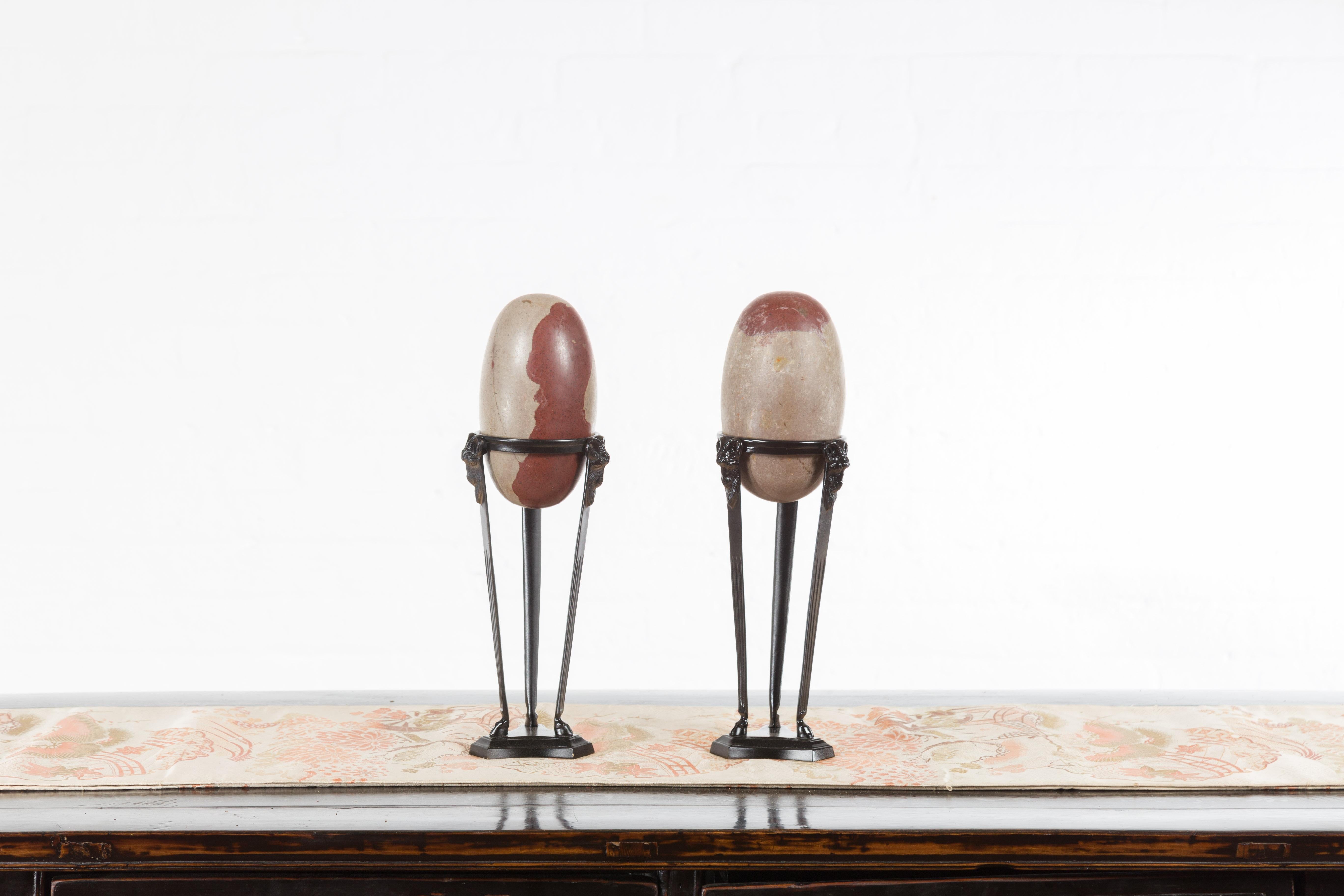 A pair of two-toned stone Shiva Linga from the Narmada River on custom stands. A perfect addition to any home décor, this pair of Shiva Linga captures the attention with their its dimensions and two-toned appearance. A sacred stone in the Indian