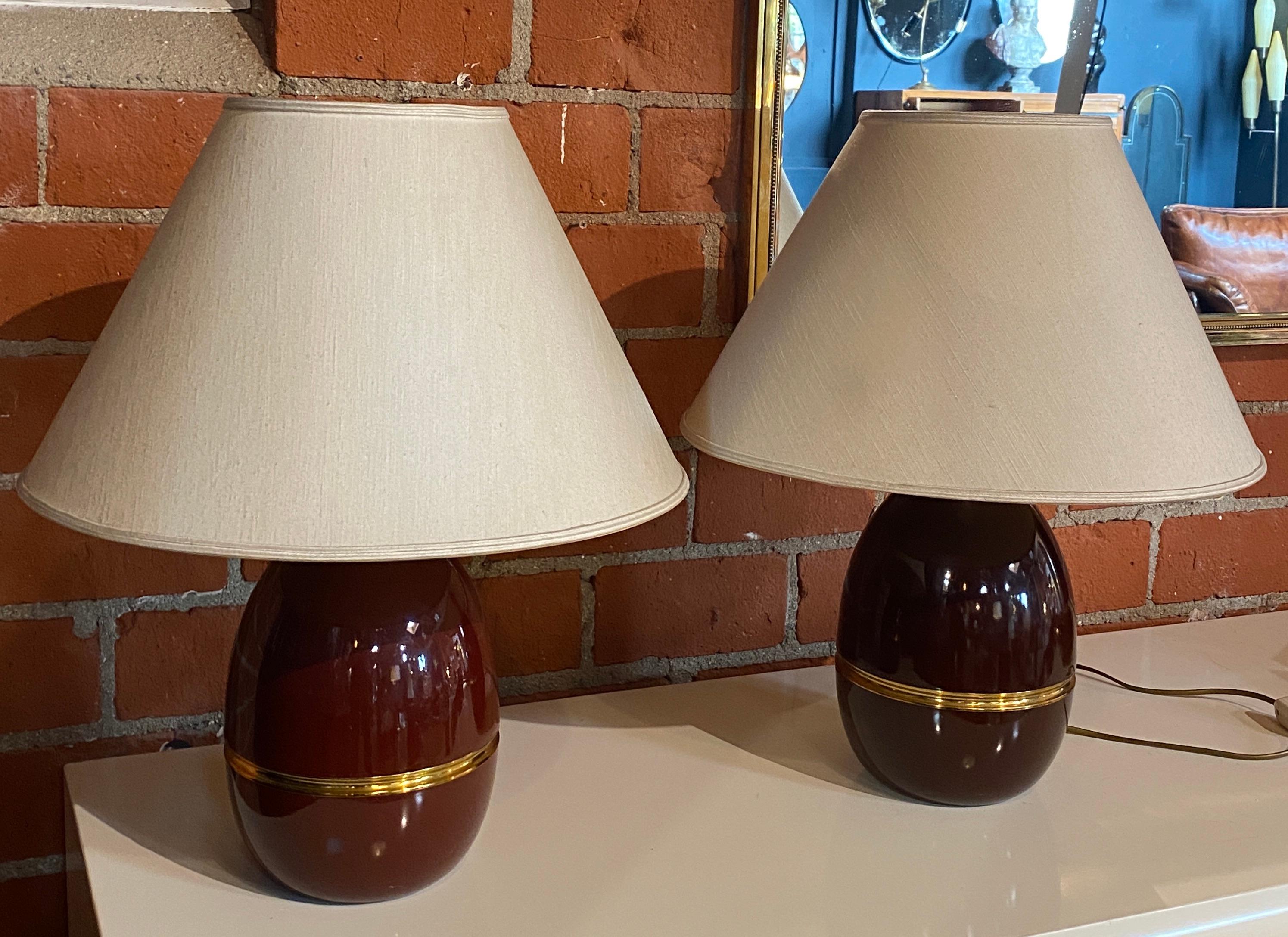 Wonderful pair of burgundy colored table lamps with a brass line in the center of the base.
The lamps are equipped with lampshades in excellent condition as the bases, as you can see the lamps have a beautiful and unique design that is ready to