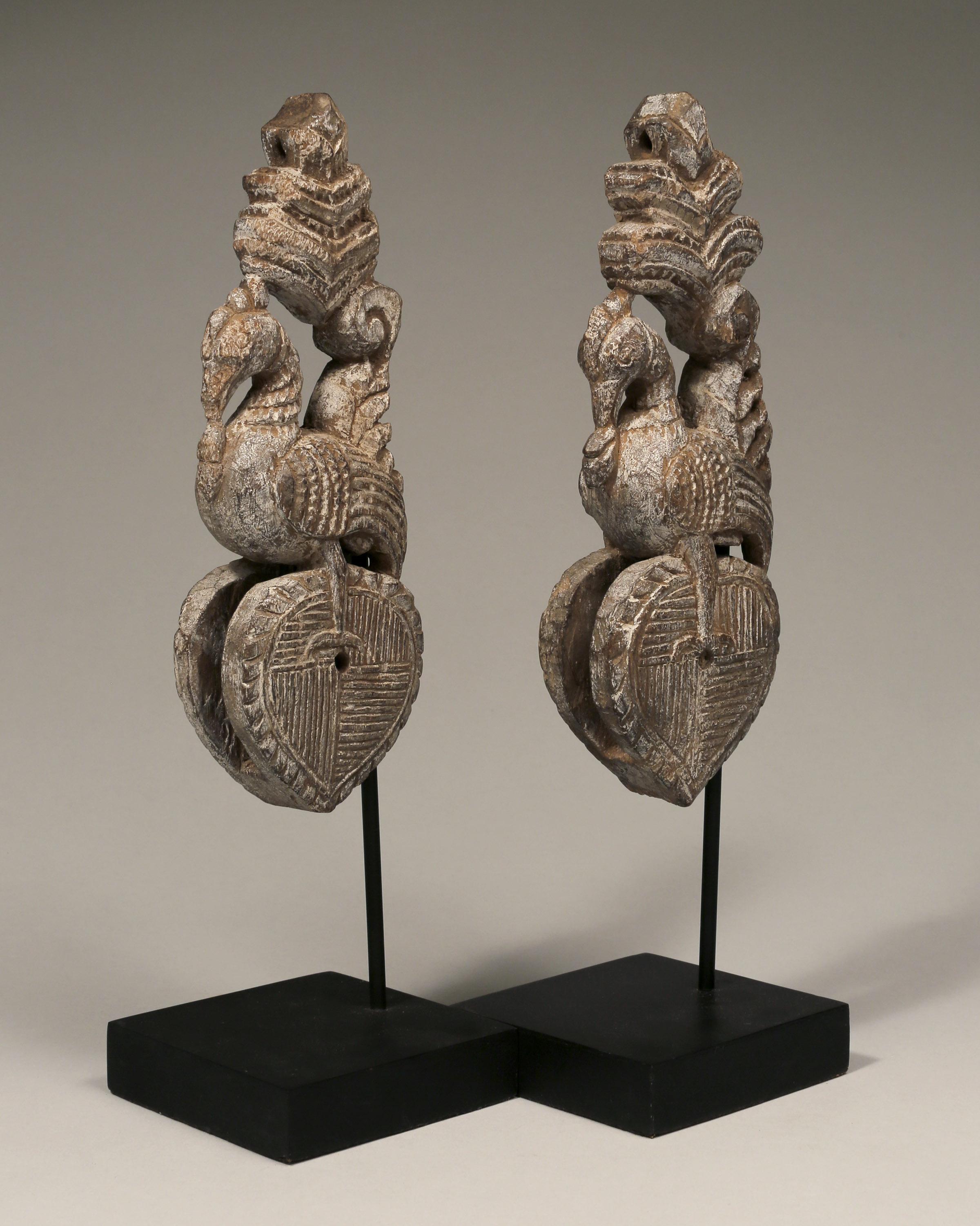 A pair of two carved wood weaving loom pulleys depicting peacocks and hearts.

Thailand,
Ca. 19th century
Wood
Measures: H 6 in x W 5 in each.